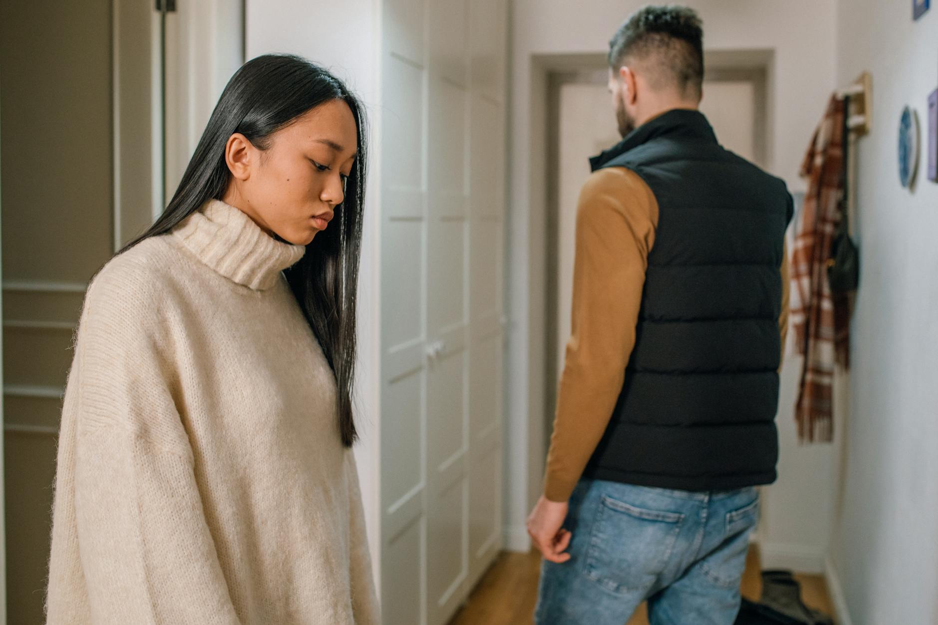 A couple experiencing relationship issues in a hallway, conveying emotional tension. - winter sleep problems