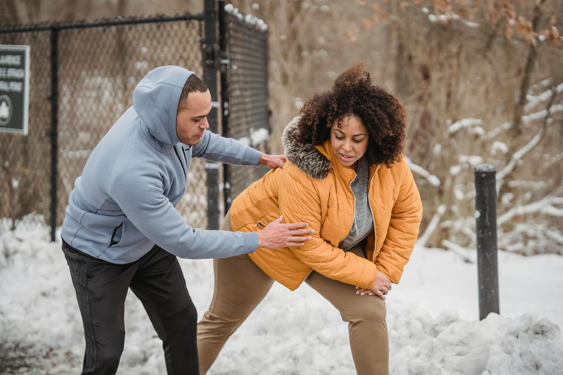 Two adults stretching in a snowy park, guided by a coach, focused on fitness and health. - winter therapy motivation