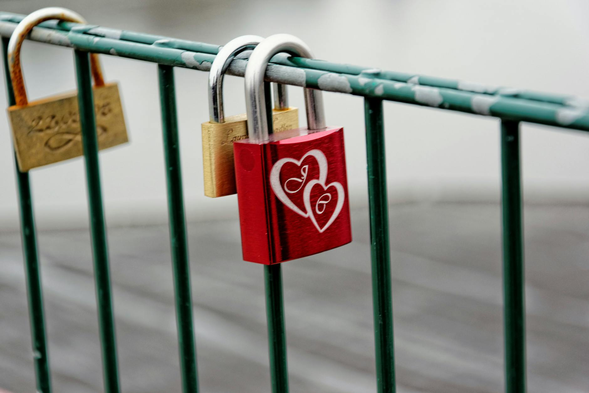 A vibrant red love padlock with heart engravings on a bridge railing symbolizing eternal love. - anxious attachment style