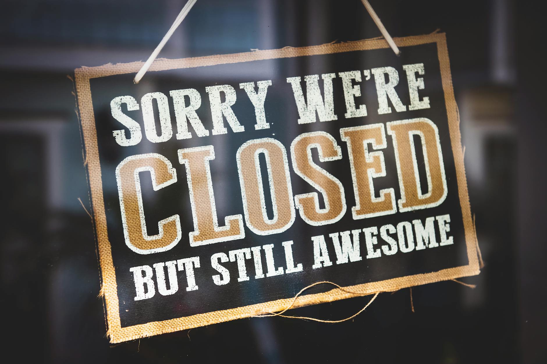 A playful closed sign on a shop door reading 'Sorry We're Closed But Still Awesome'. - how to apologize