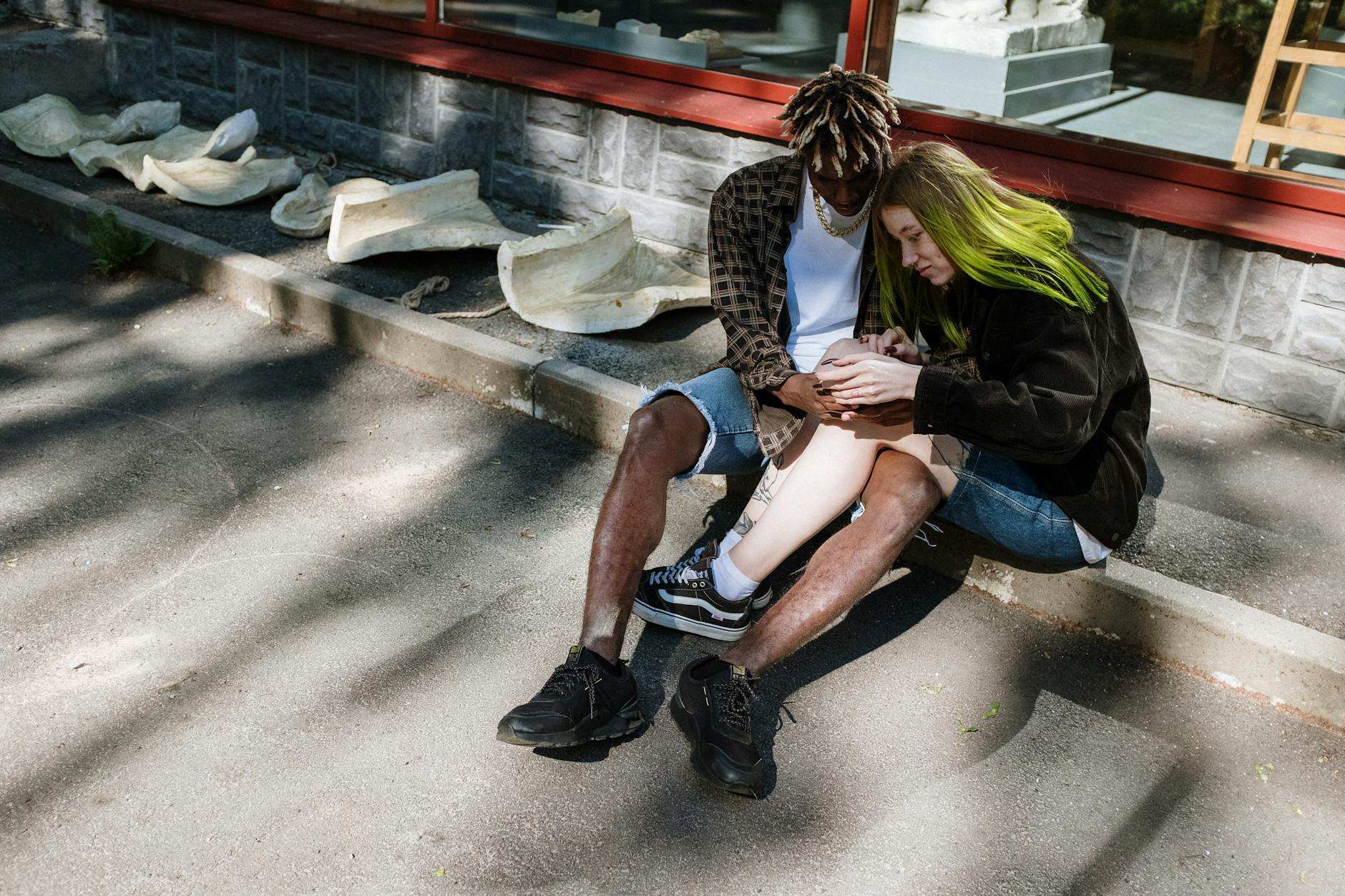 A modern couple sits together outdoors, showcasing a loving relationship in an urban setting. - how to apologize to a guy
