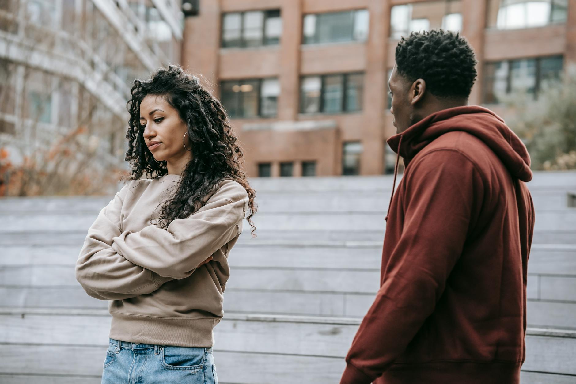A couple in a heated argument outside, displaying frustration and dissatisfaction. - apologize to a man