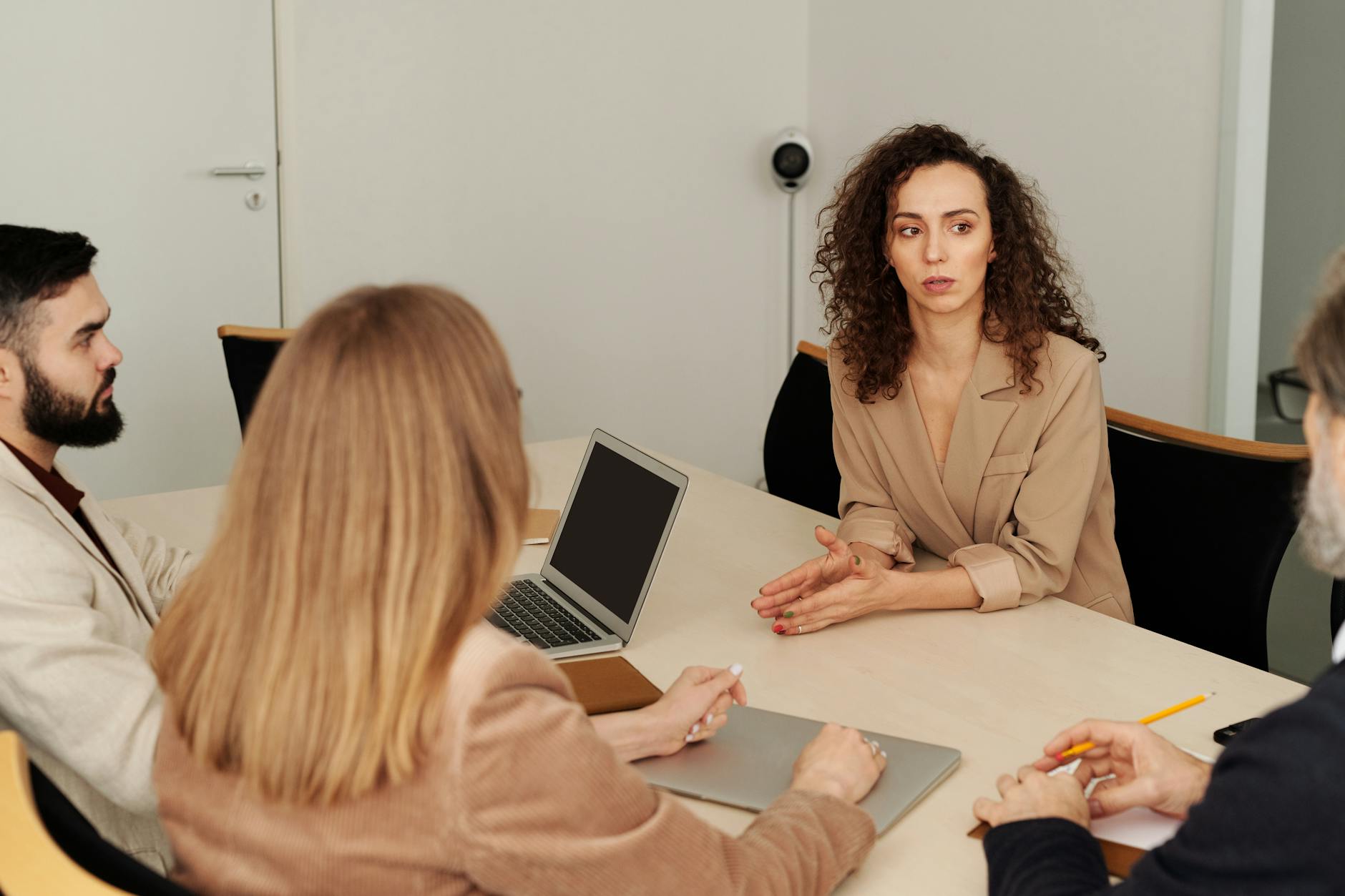 A diverse team of professionals engaged in a business meeting in a modern office setting. - assertive communication examples