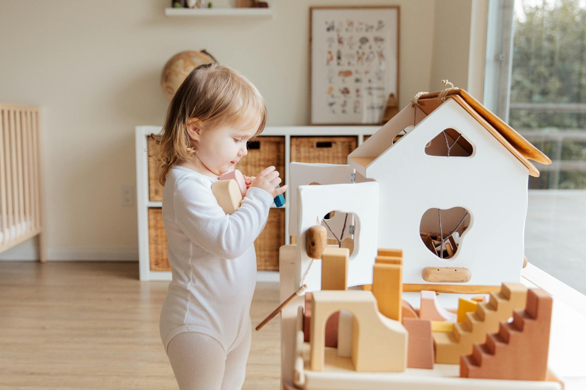 Cute toddler engaging with wooden toys in a bright indoor setting. - child developmental milestones