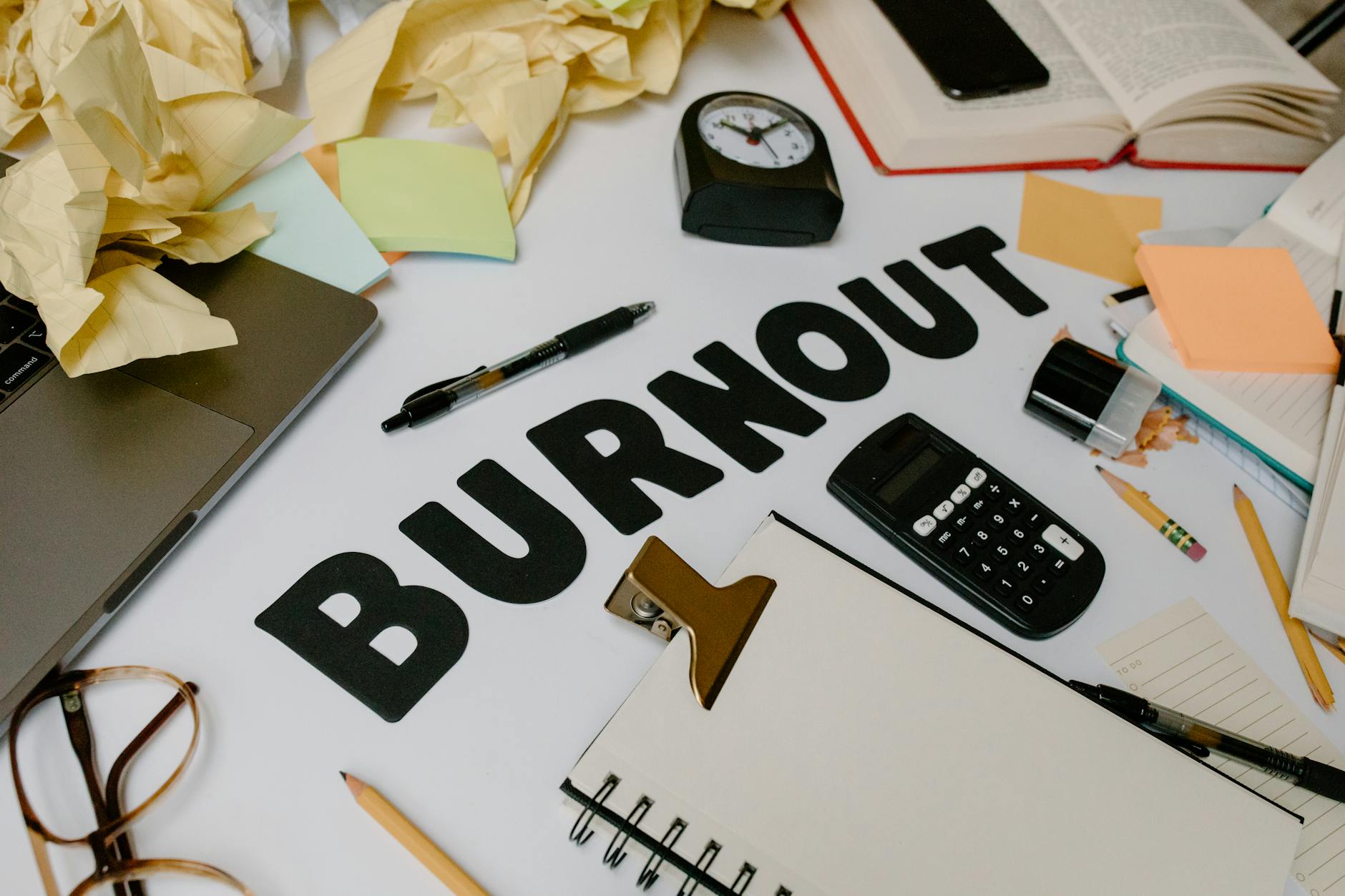 A cluttered office desk symbolizing burnout and stress, with crumpled papers and office supplies. - clear mental clutter