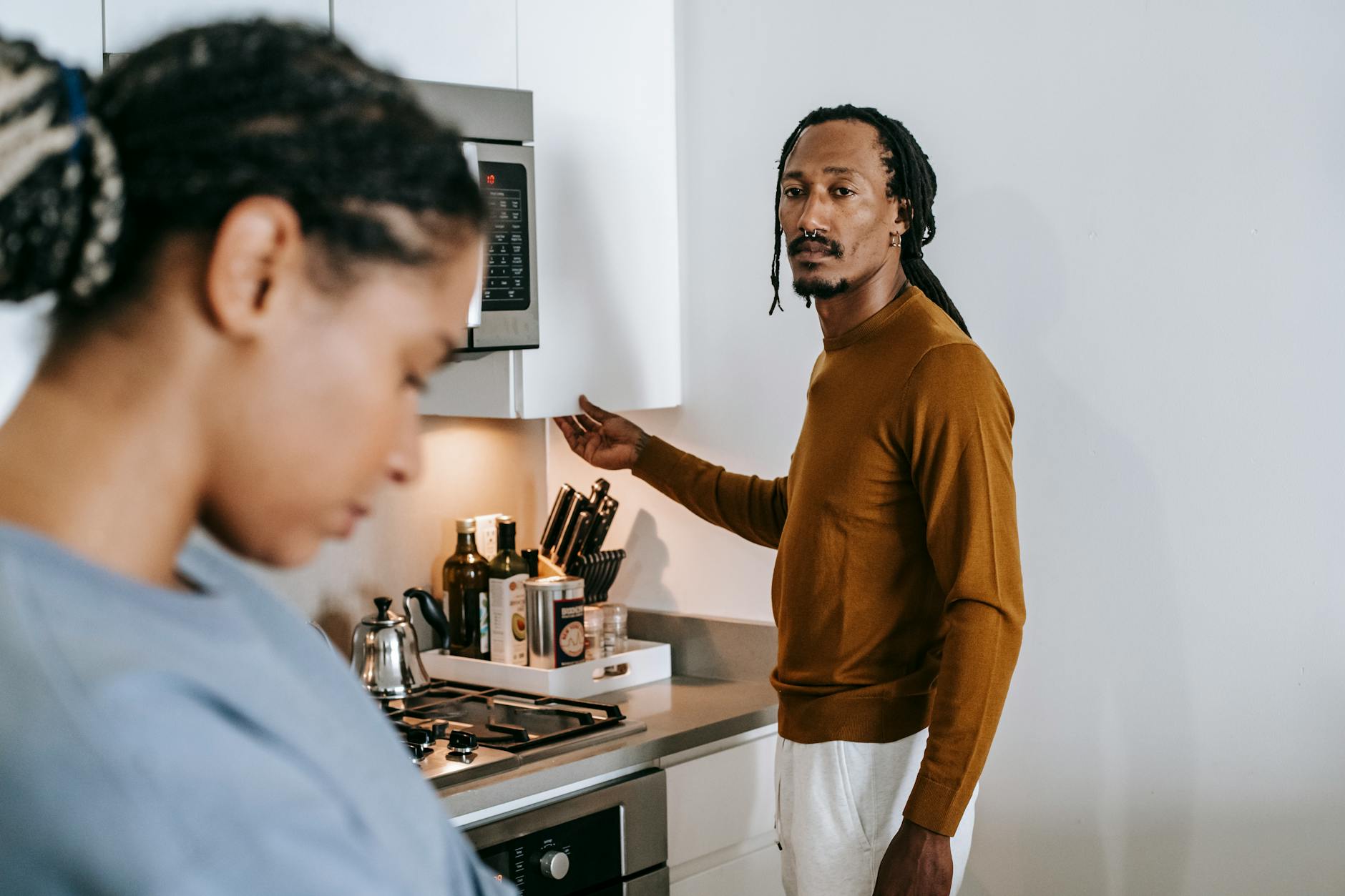 A young couple in their kitchen, visibly upset and in a tense discussion. - what is conflict
