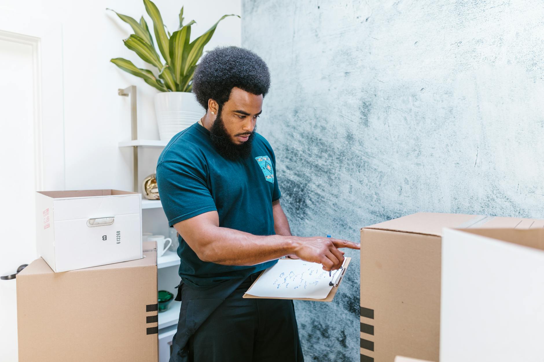 Mover checking inventory list while organizing cardboard boxes in a new apartment. - couple communication tips