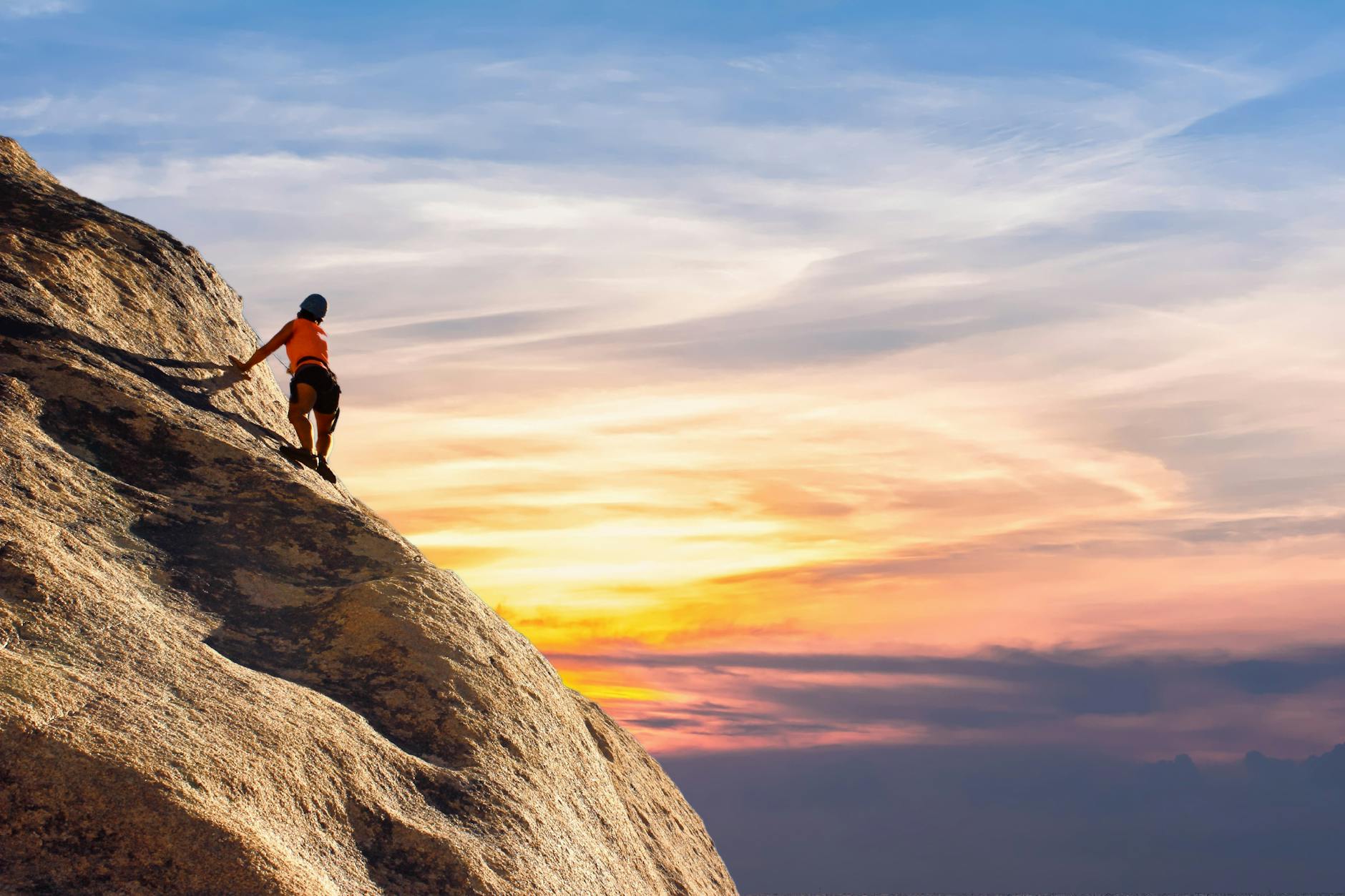 Climber conquers rock face at sunset, embracing the thrill and challenge. - difficult conversations