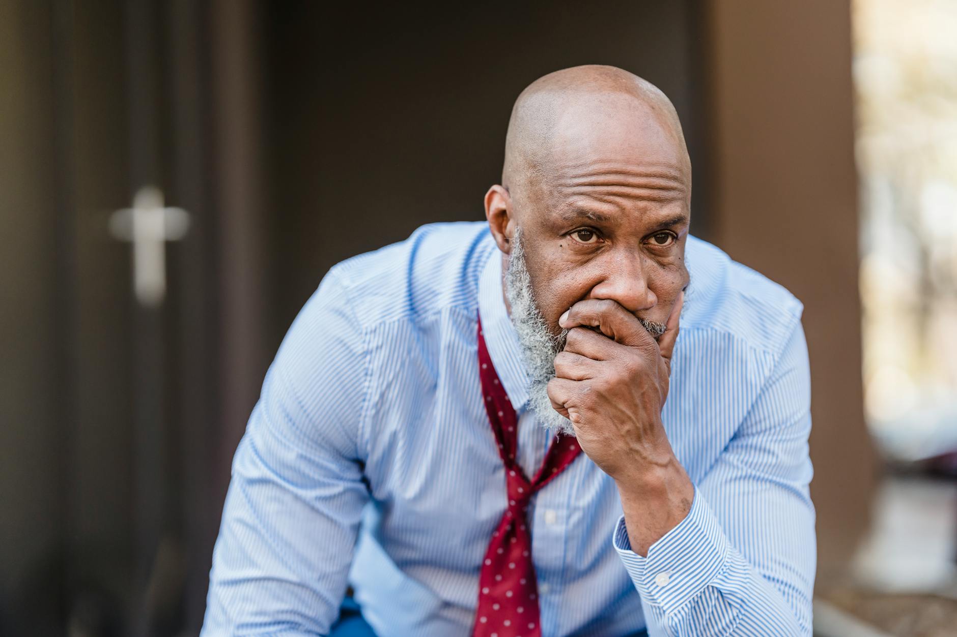 Thoughtful middle-aged man in business attire sitting outdoors, pondering solutions to a problem. - difficult conversations