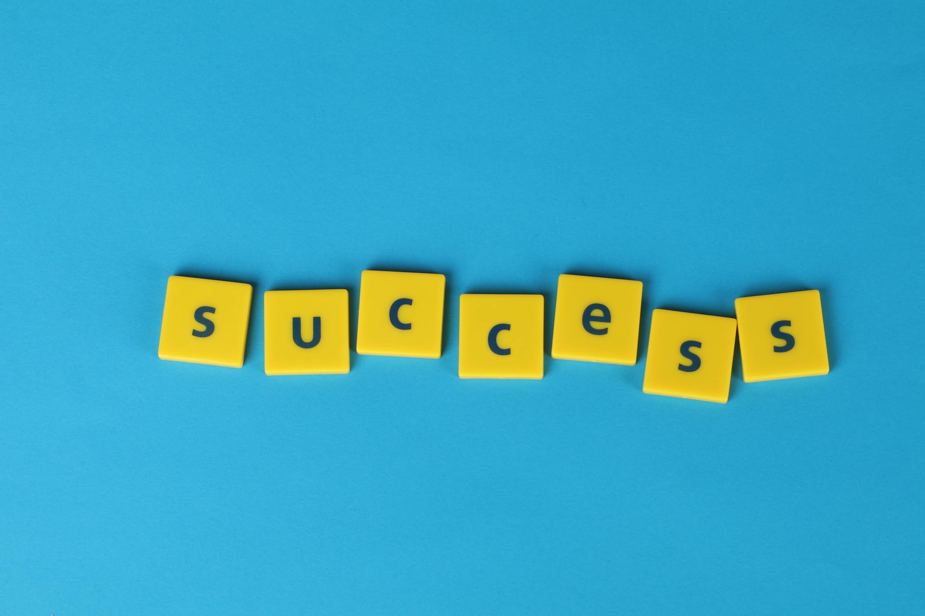 Yellow letter tiles spell the word success on a vibrant blue backdrop, symbolizing achievement. - effective communication spring plans
