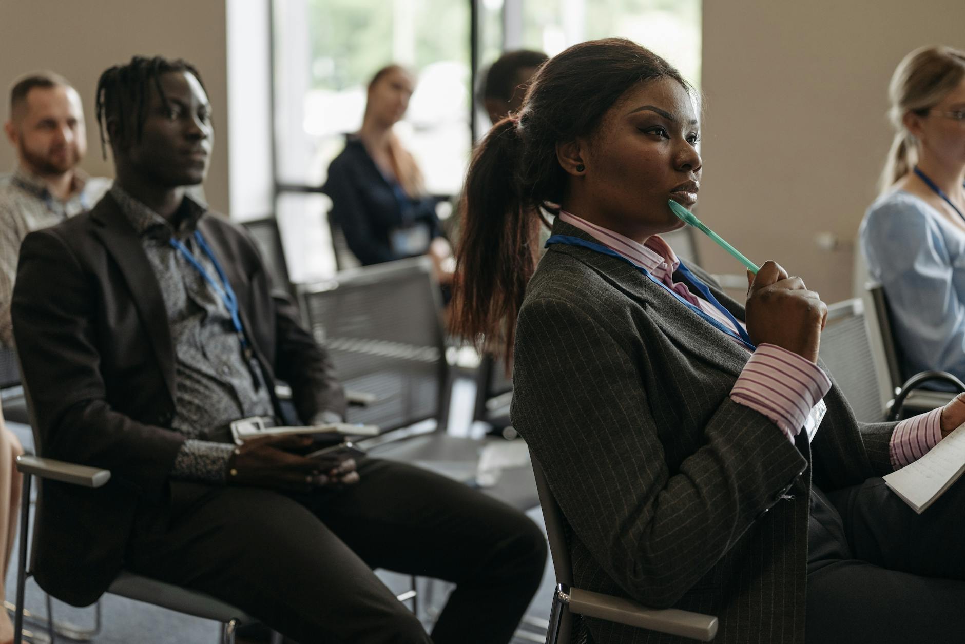 Diverse group of professionals attentively listening in a business conference setting. - effective listening skills