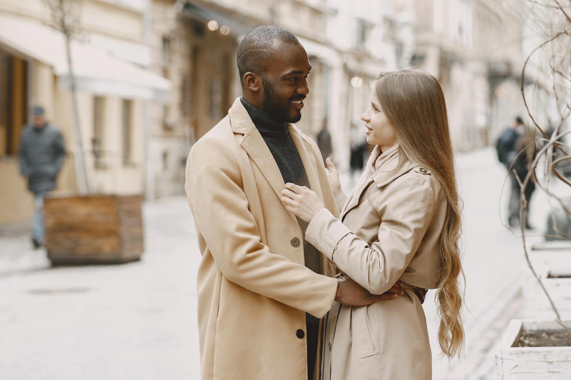 Happy interracial couple embracing outdoors in stylish winter clothing, expressing love and togetherness. - express gratitude partner
