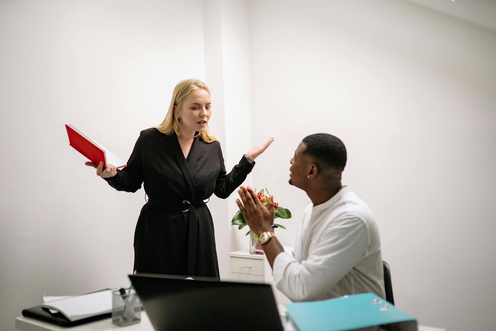 Colleagues in an animated discussion in an office setting, highlighting workplace communication. - express needs conflict