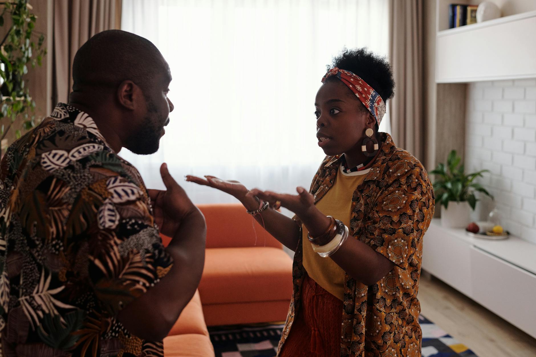 A couple arguing passionately in their living room, expressing emotions and gestures. - express needs conflict