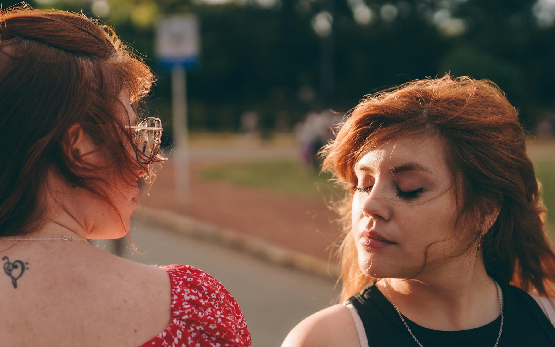 Two redheaded women in an outdoor setting enjoying a sunny day together. - what is gaslighting