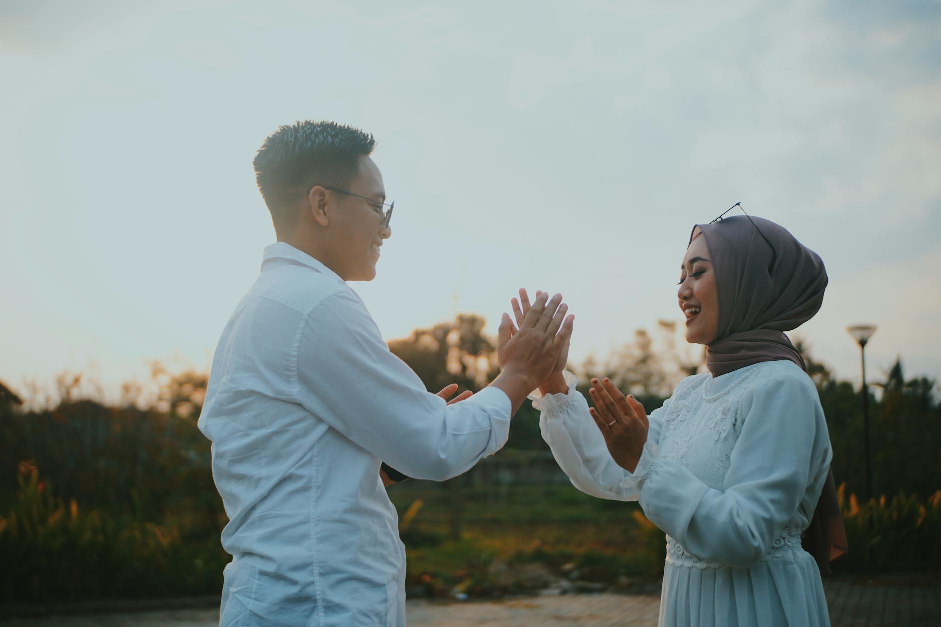 Joyful couple in traditional attire shares a playful moment outdoors at sunset, embracing love and togetherness. - gratitude in marriage