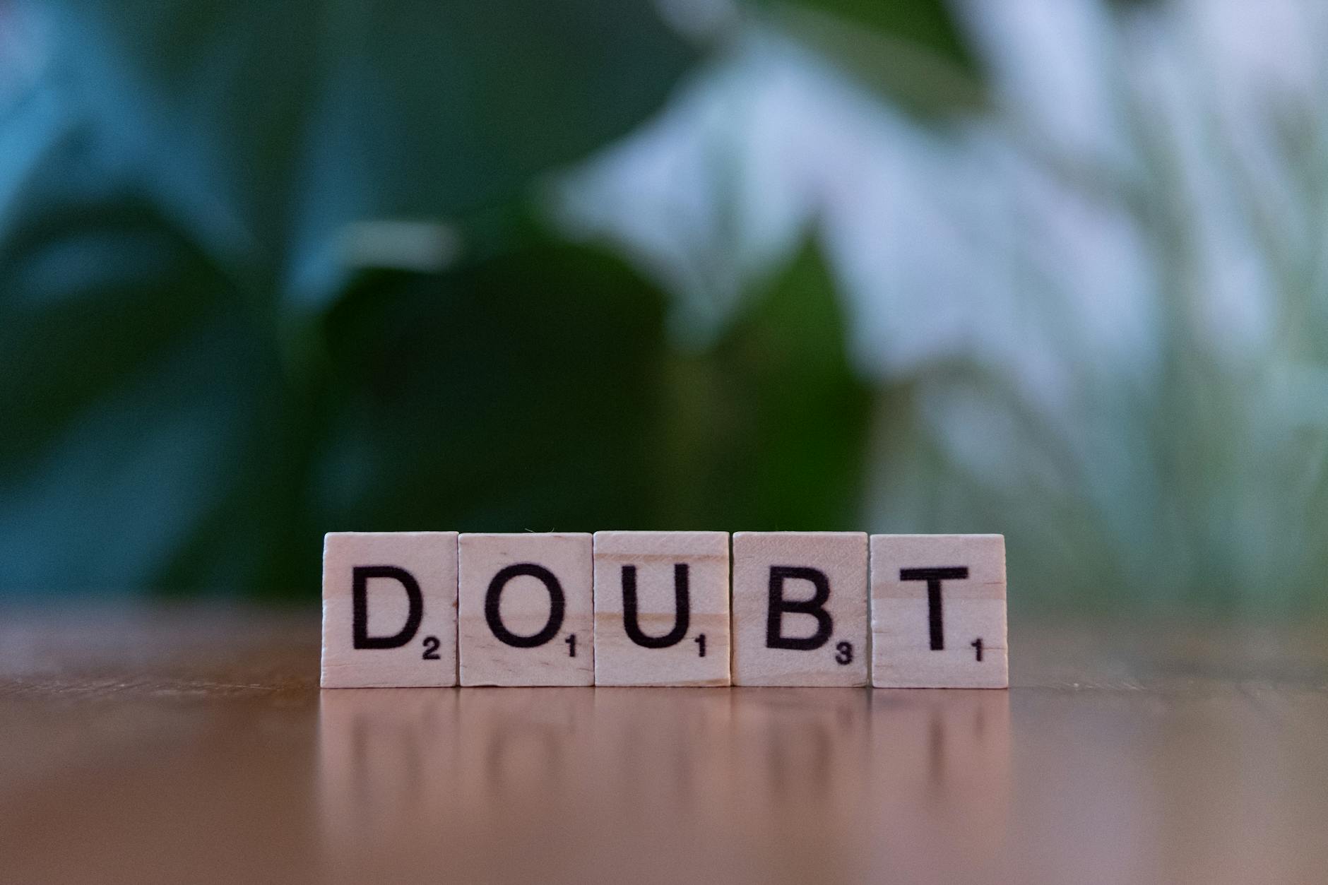 Close-up of Scrabble tiles spelling 'doubt' on a wooden surface, conveying uncertainty. - lack of empathy