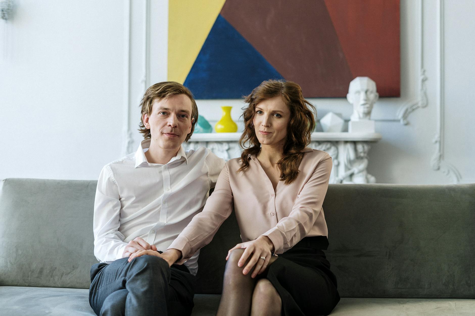 A couple sitting on a couch during a counseling session, showing connection and support. - marriage advice men