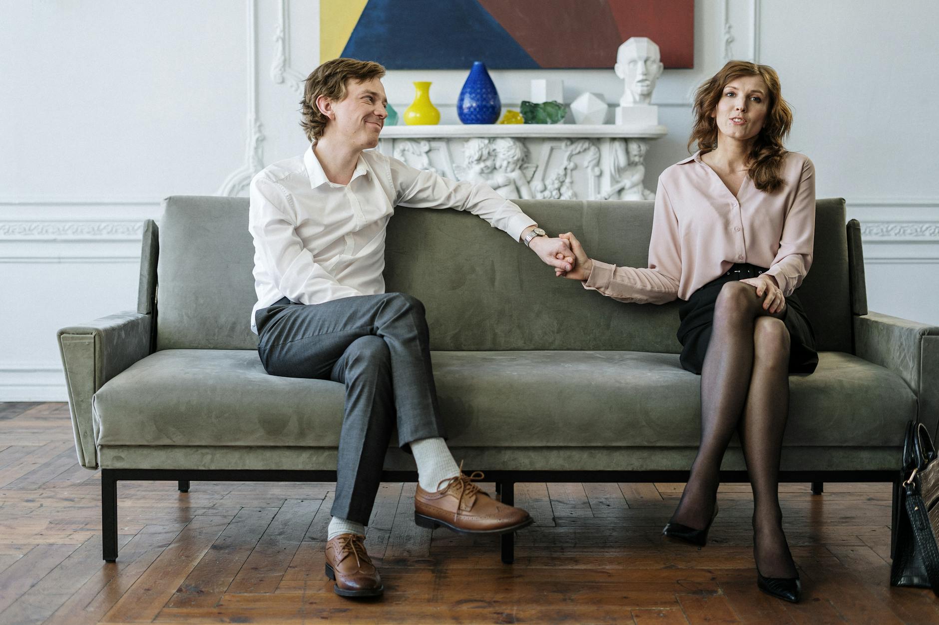 A couple in a therapy session holding hands, conveying support and connection. - marriage advice men