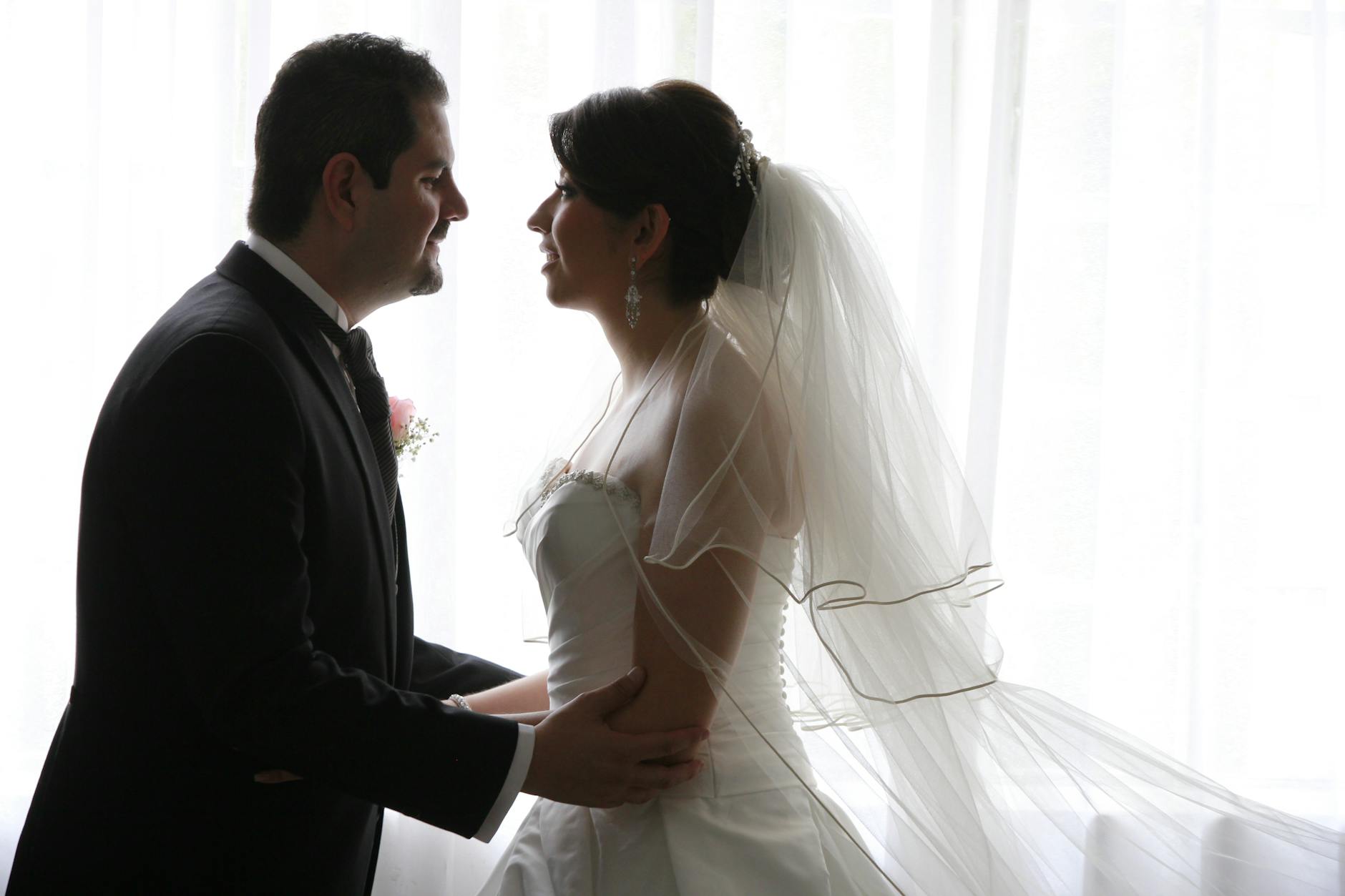 A beautiful wedding portrait depicting a bride and groom sharing an intimate moment indoors. - marriage advice women