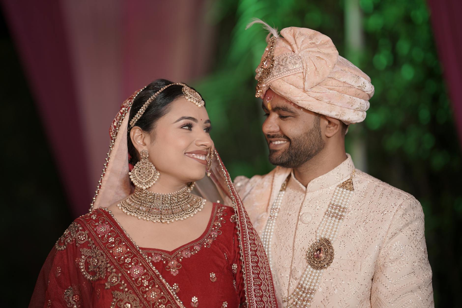 A joyful Indian couple in traditional wedding attire, adorned with intricate embroidery and jewelry. - marriage communication tips