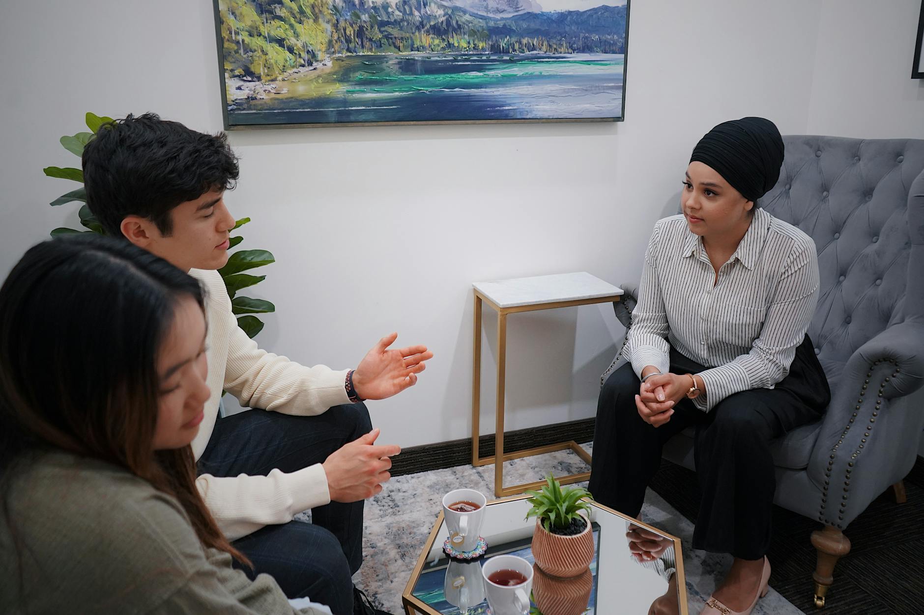 A couple in a therapy session discussing issues with a therapist in a modern office. - midlife relationship counseling