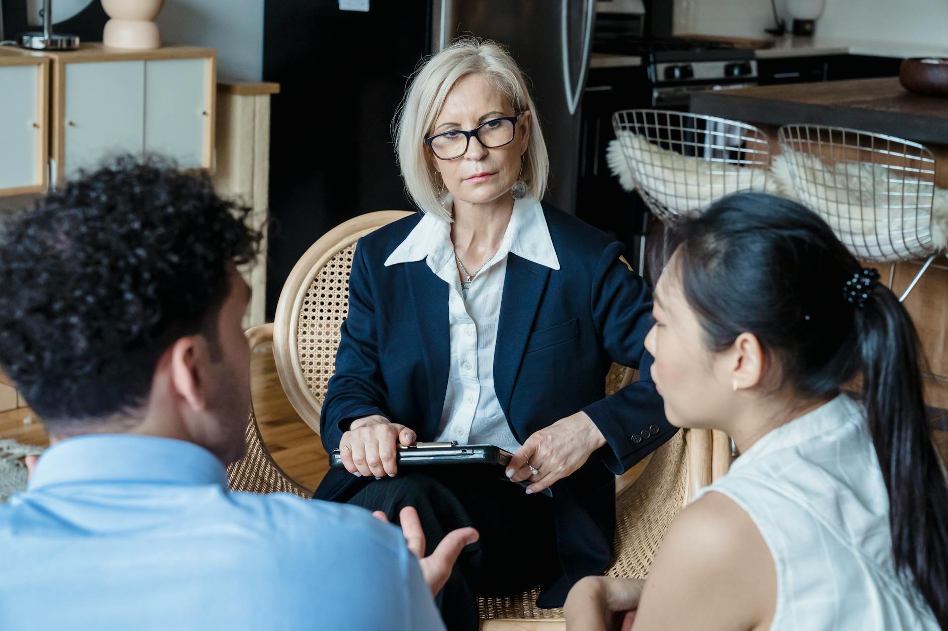 A professional therapist engages with a couple during a counseling session indoors. - midlife relationship counseling
