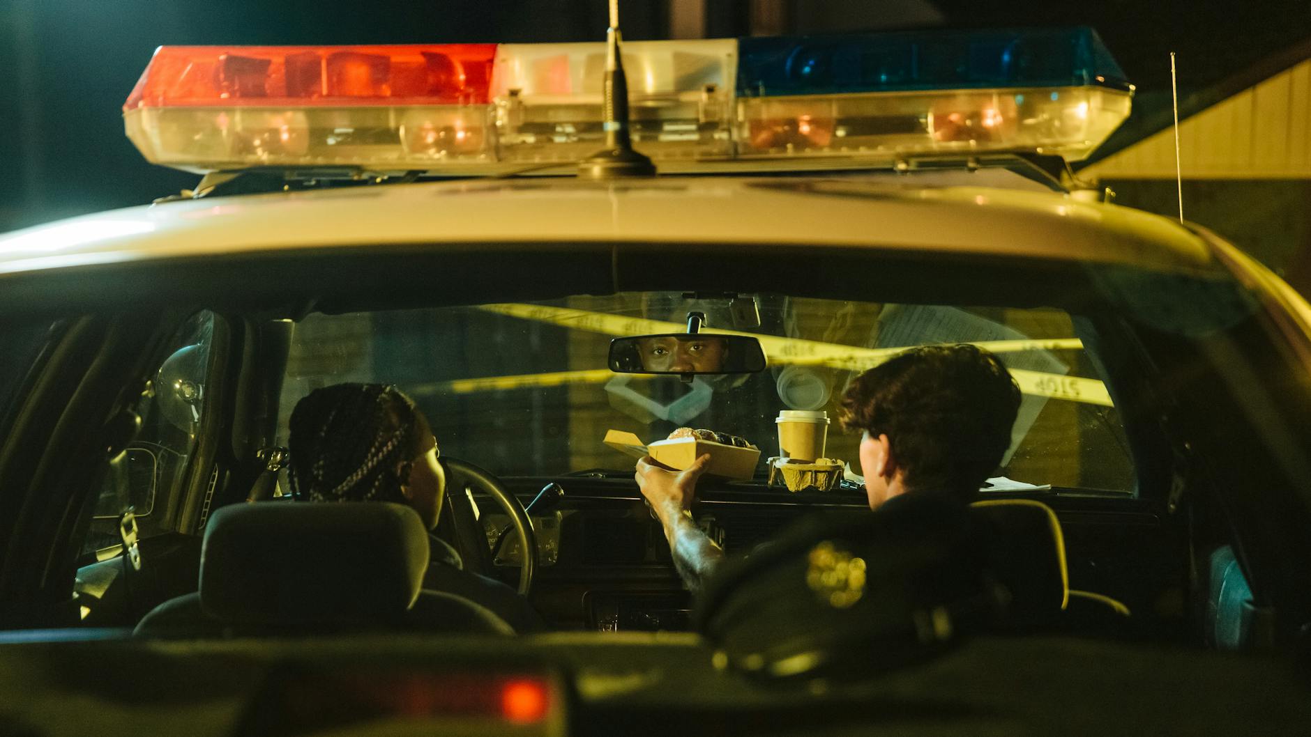 Two police officers eating in their patrol car during a nighttime shift. - navigating spring break in-laws