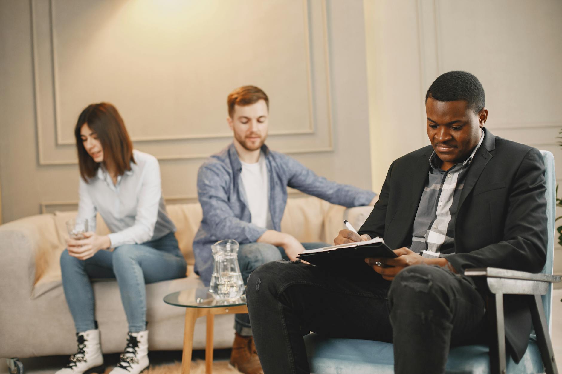 A couple discussing issues with a therapist during a counseling session indoors. - pre-marriage counseling