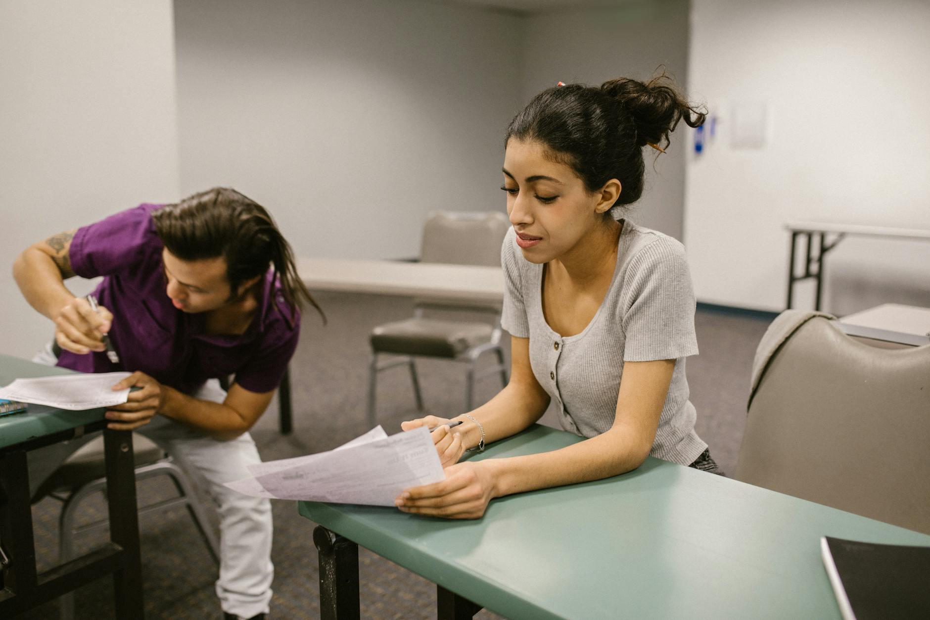 Two students in a classroom setting during an exam, one appearing to assist the other. - rebuilding trust cheating