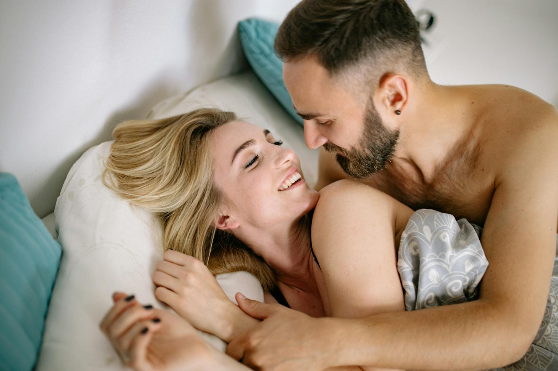 A joyful couple embracing in bed, depicting warmth and intimacy. - rekindle intimacy long term relationships