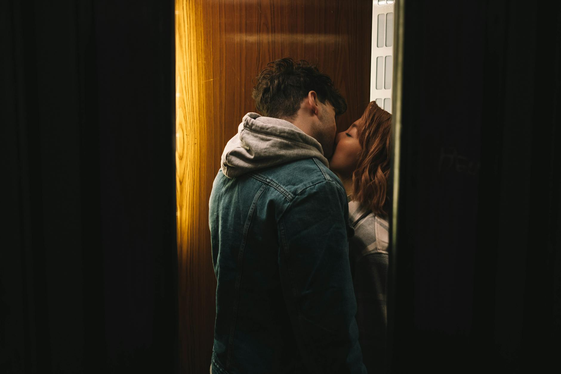 A couple shares an intimate kiss in a cozy elevator setting, conveying love and affection. - rekindle romance