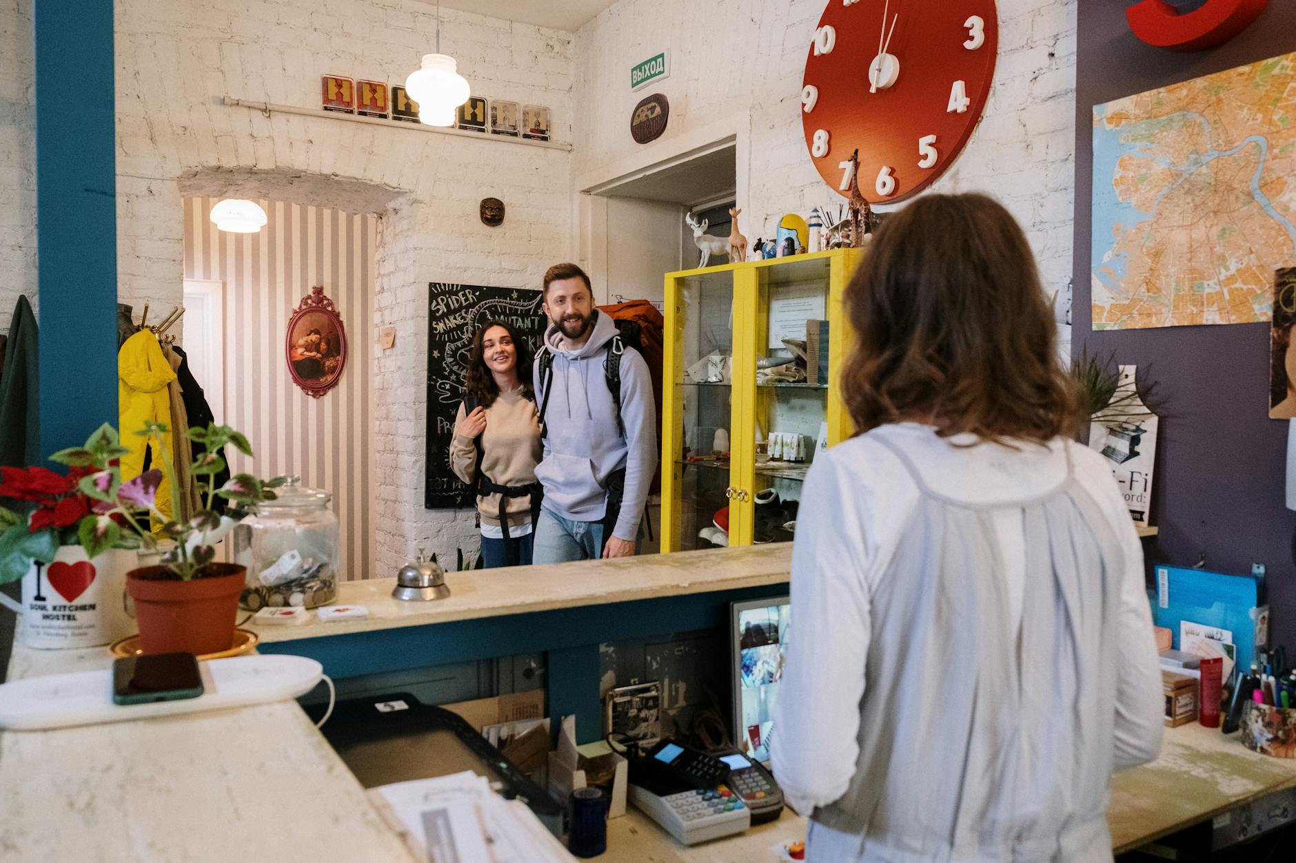 Friendly hostel reception area with travelers checking in, providing a warm and welcoming atmosphere. - relationship communication check-in