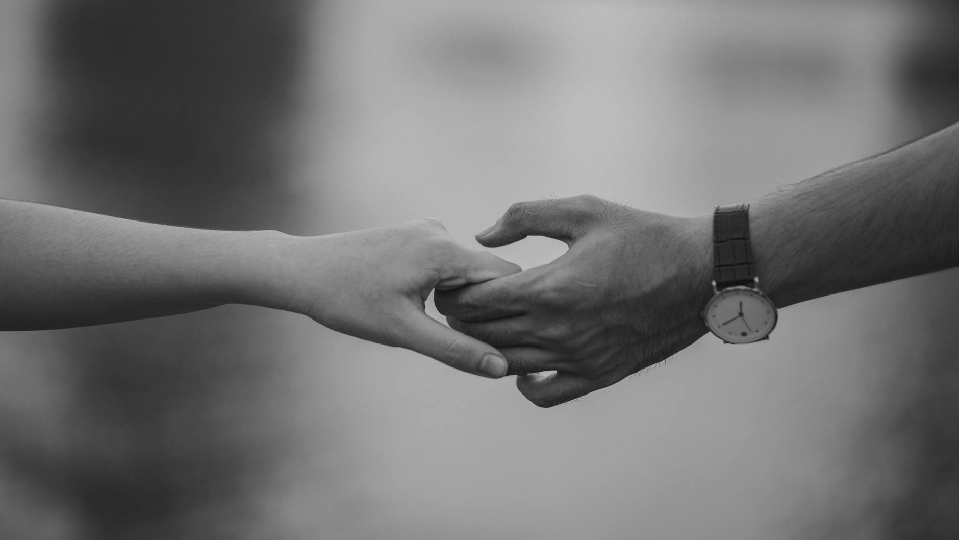 Monochrome image of two hands holding, symbolizing love and connection. - relationship healing