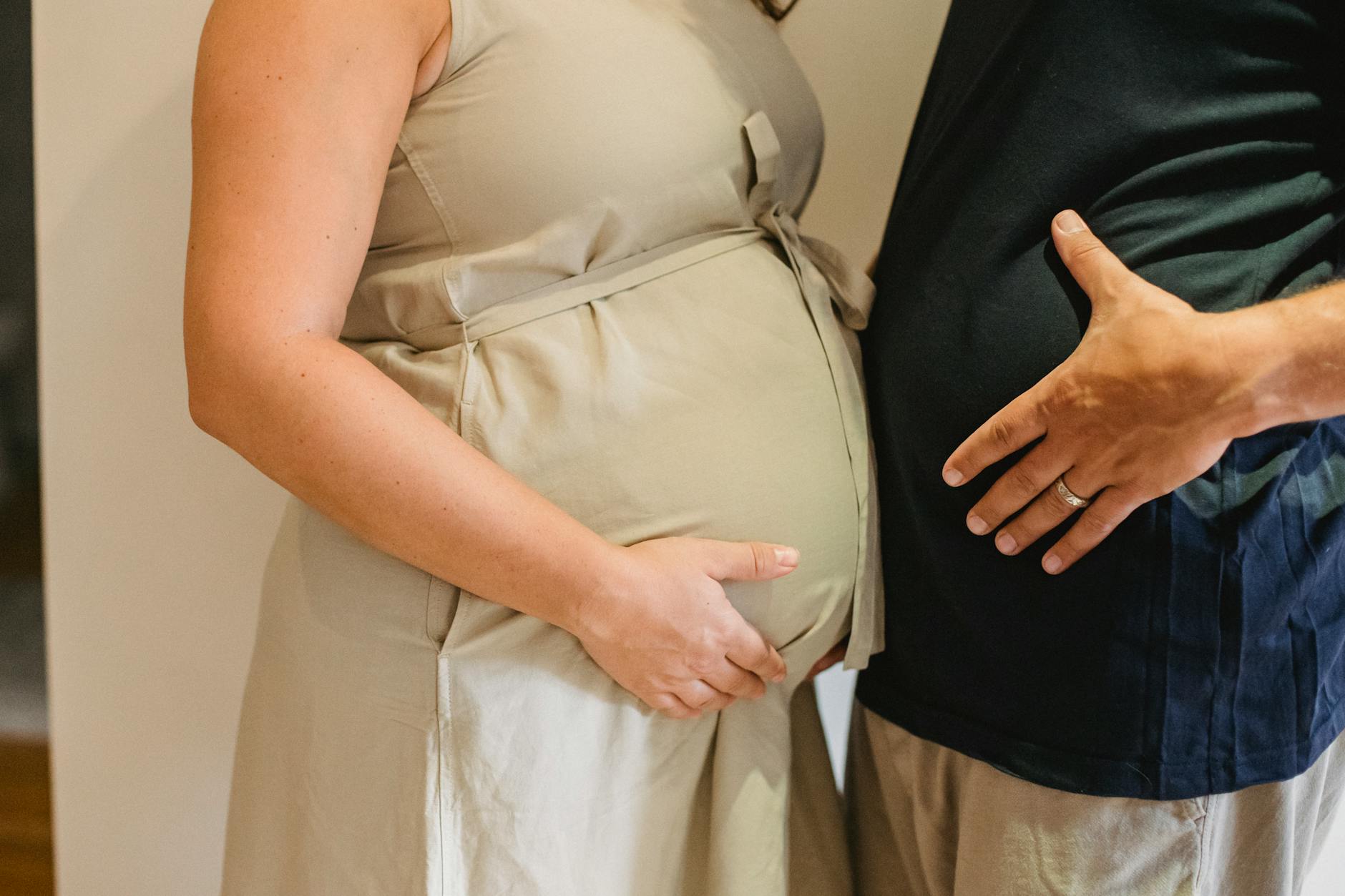 Close-up of a couple gently touching pregnant bellies, symbolizing love and anticipation. - reset relationship expectations
