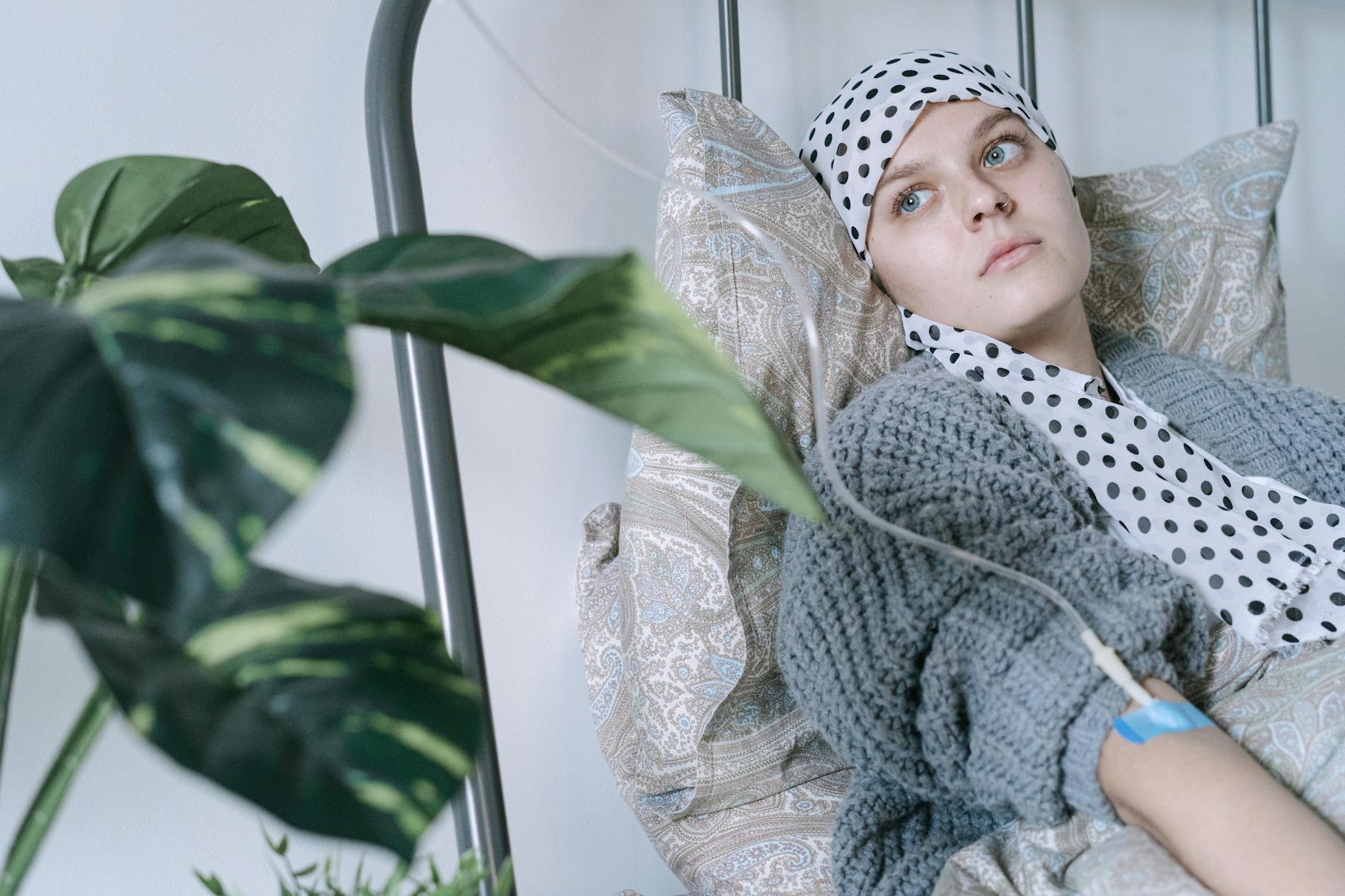 Young woman in hospital bed receiving cancer treatment, reflecting resilience. - sadness therapy spring