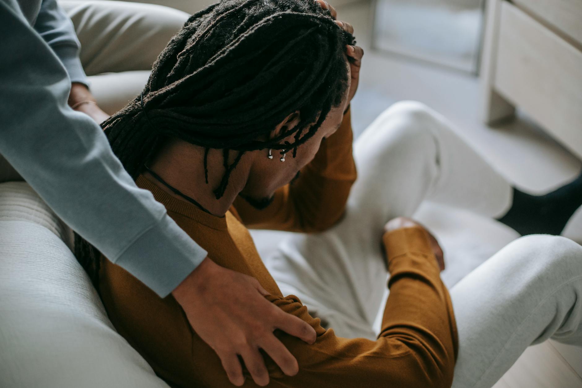 High angle of anonymous young black couple in casual clothes spend time together while calming each other in bedroom in daylight - spring anxiety relief