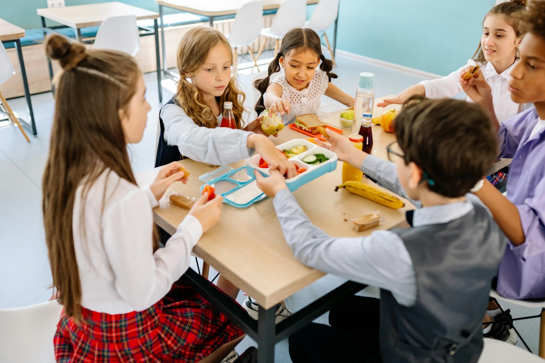 Group of diverse children having lunch in a school canteen, sharing and enjoying healthy snacks. - spring break kids