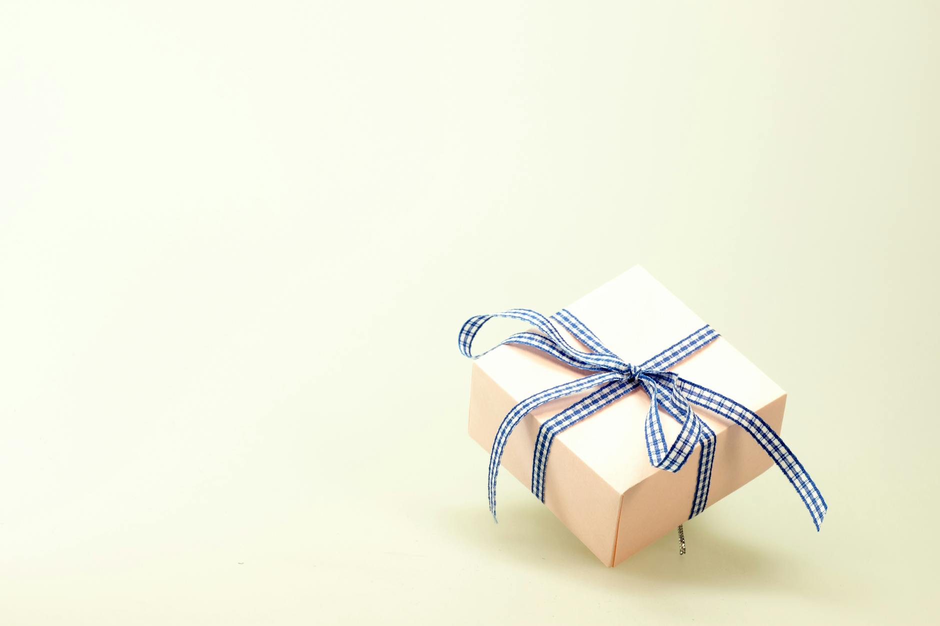 Pink gift box with blue ribbon on a soft background, perfect for celebrations and branding. - spring chore division