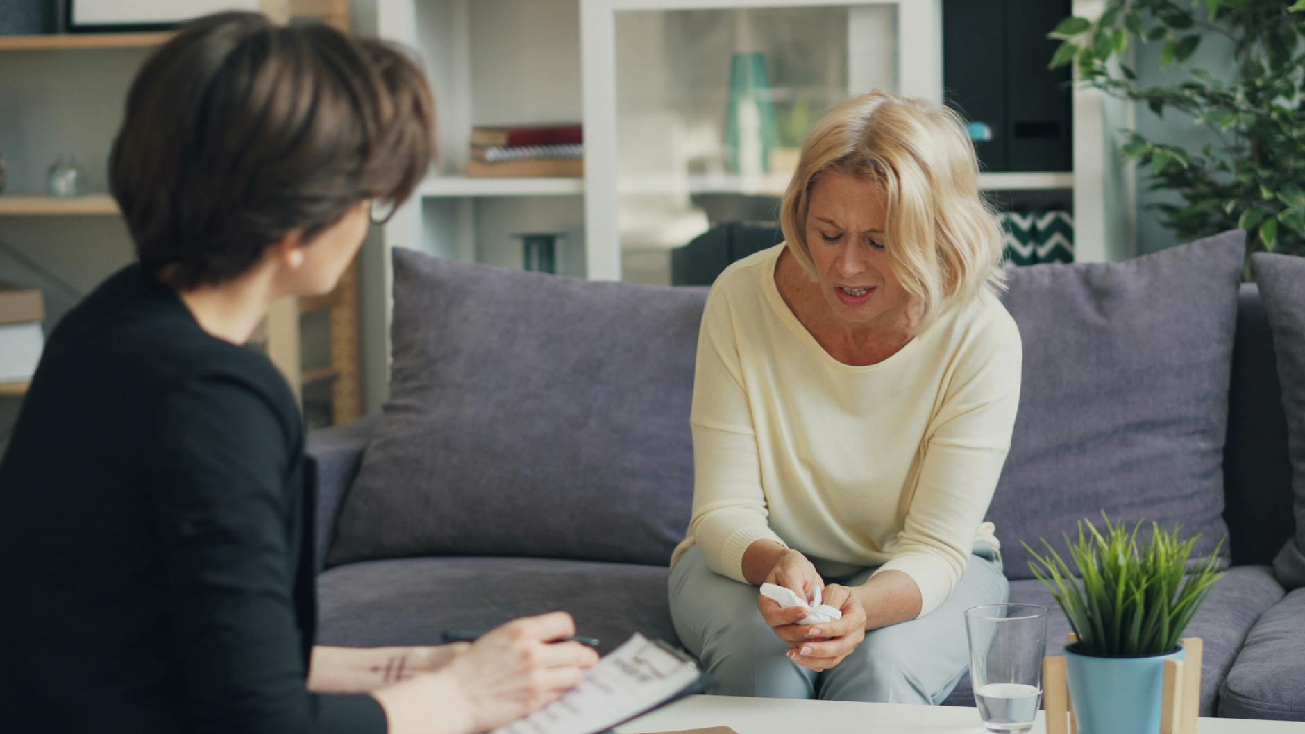 A woman in therapy session with a professional therapist, expressing emotions. - spring depression help