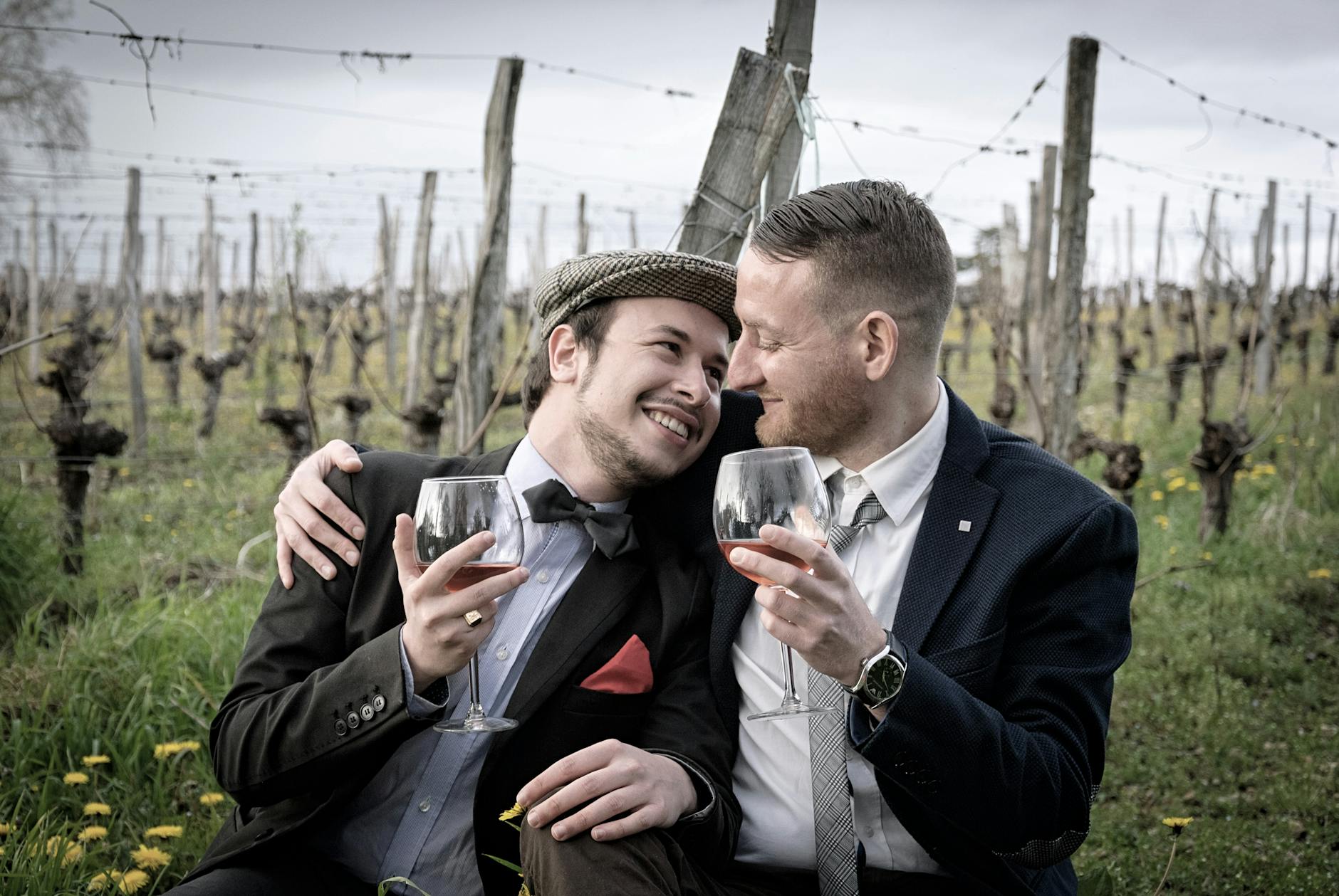 Happy couple in vineyard hugging and sharing a glass of wine, showcasing romance and joy outdoors. - spring outdoor date ideas