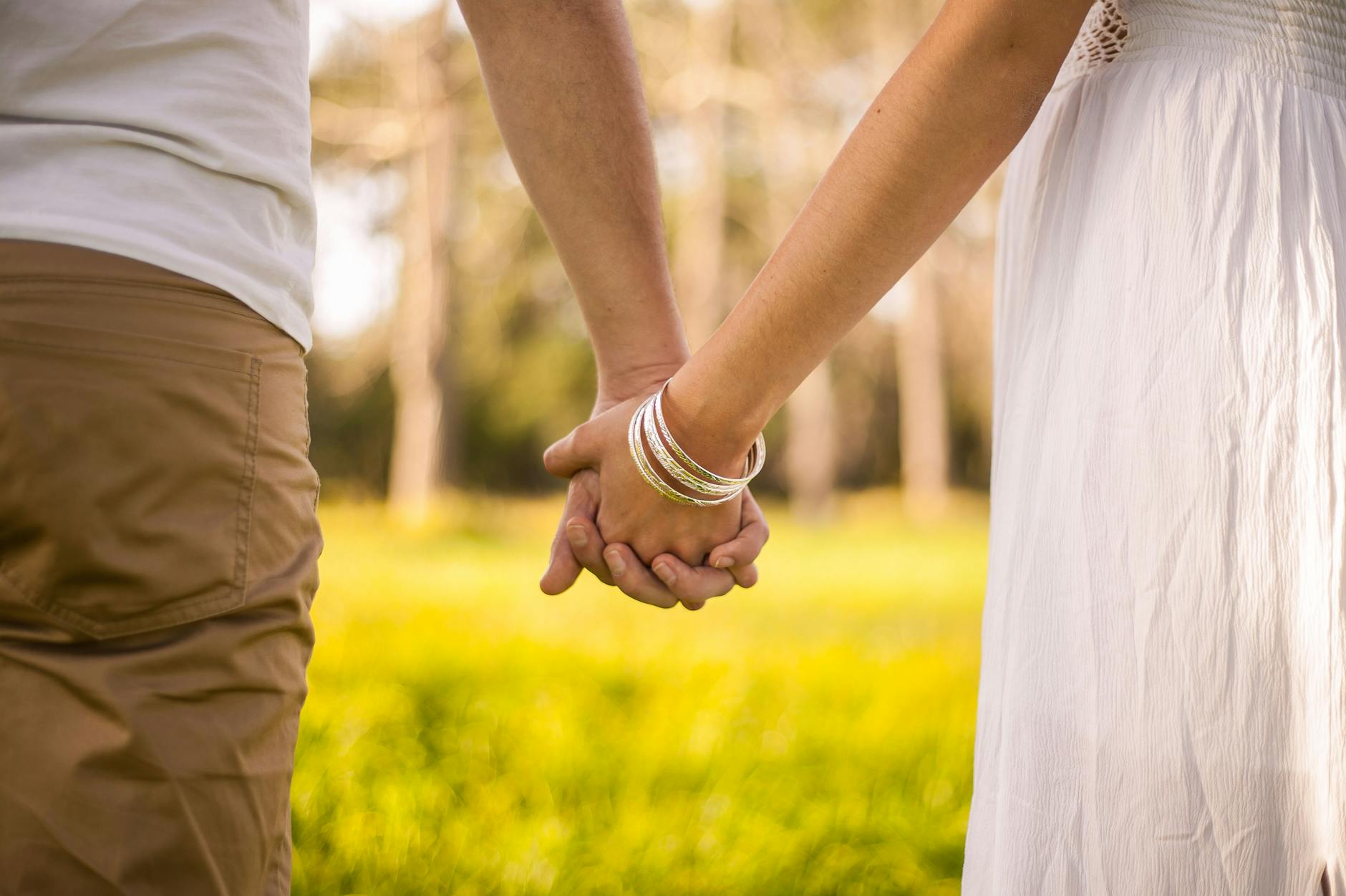 A romantic scene of a couple holding hands outdoors, capturing love and connection in spring. - spring relationship reconnection