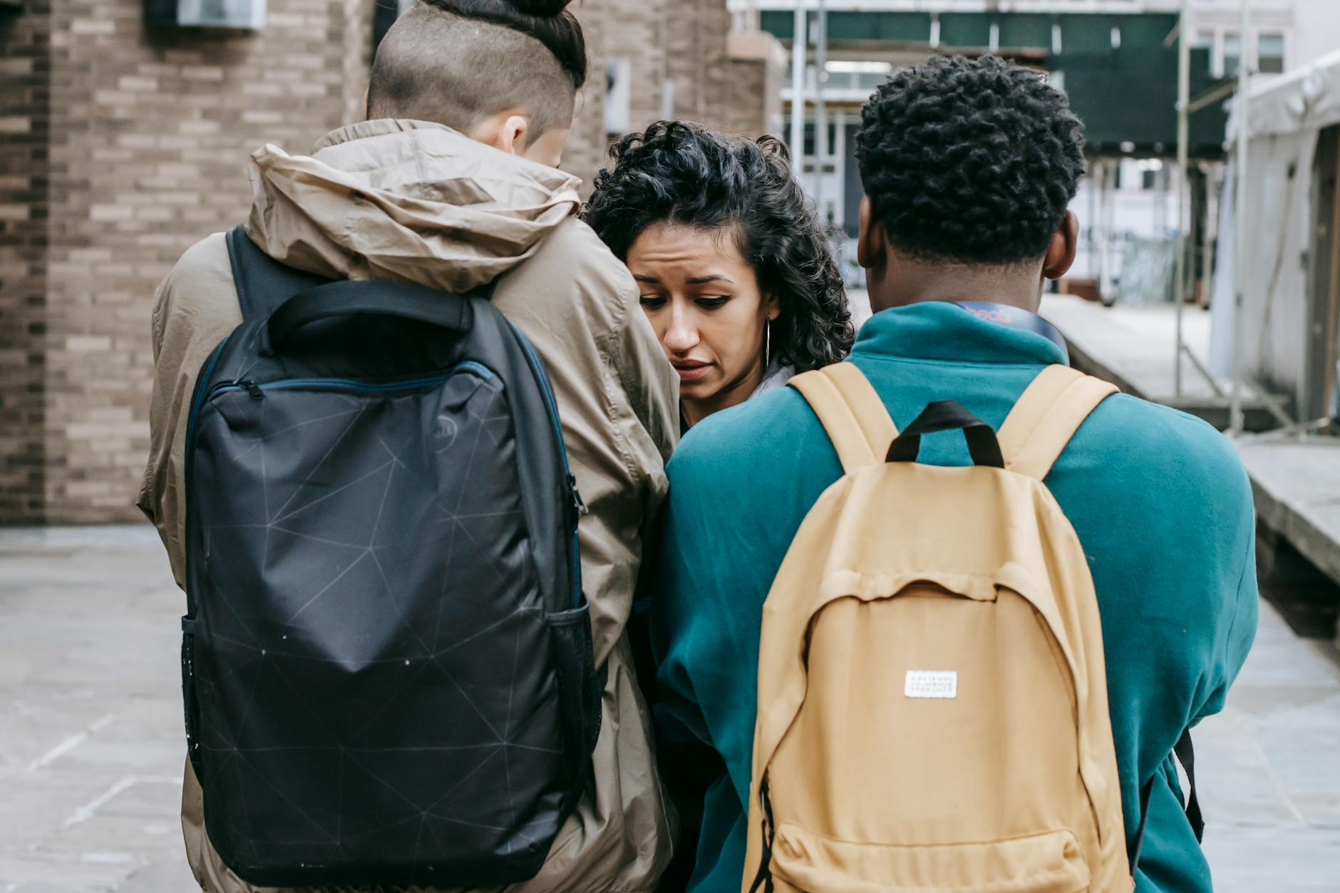 A tense interaction between diverse university students outdoors, showcasing conflict and emotion. - spring social anxiety