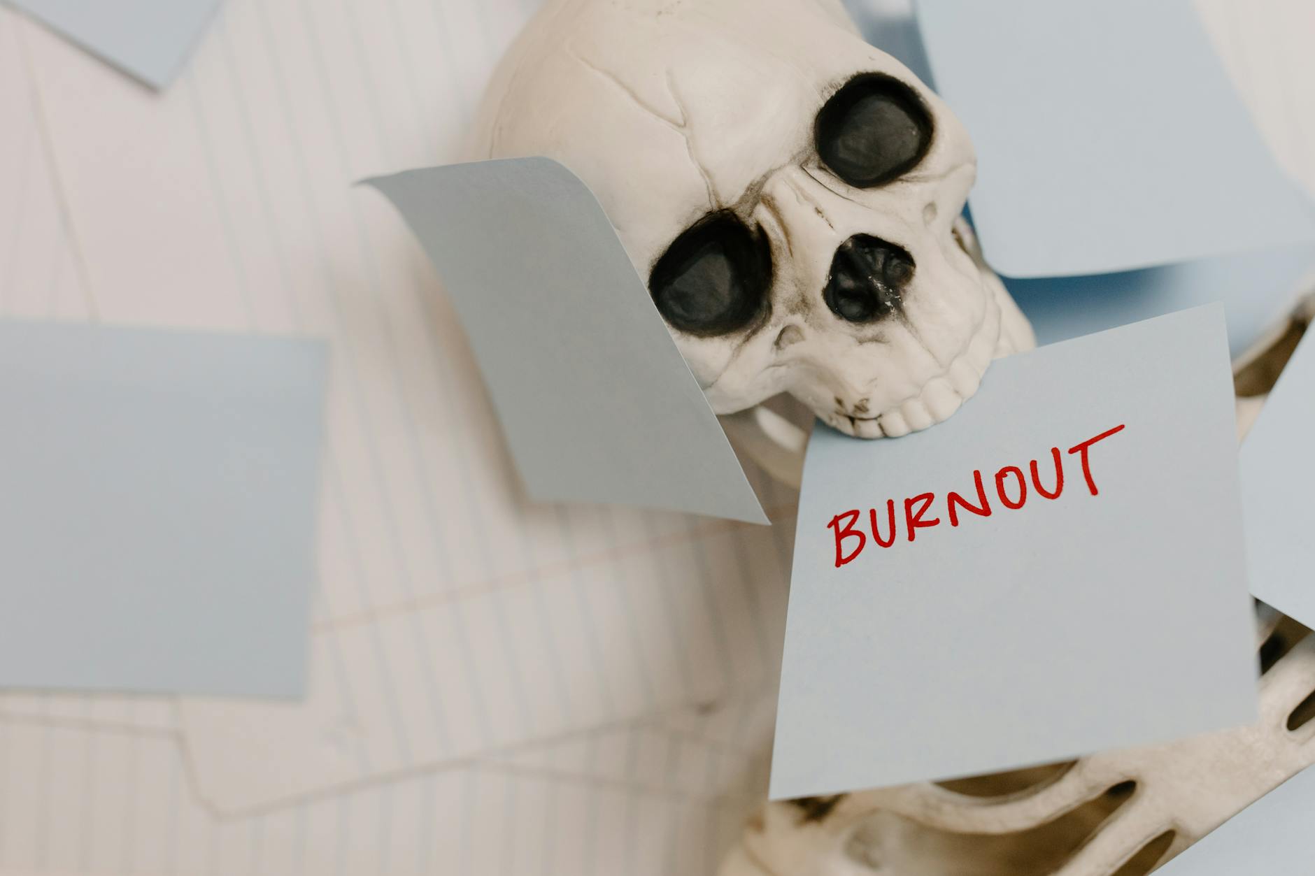 Skeleton surrounded by sticky notes symbolizes burnout and exhaustion in a dramatic setup. - spring stress relief