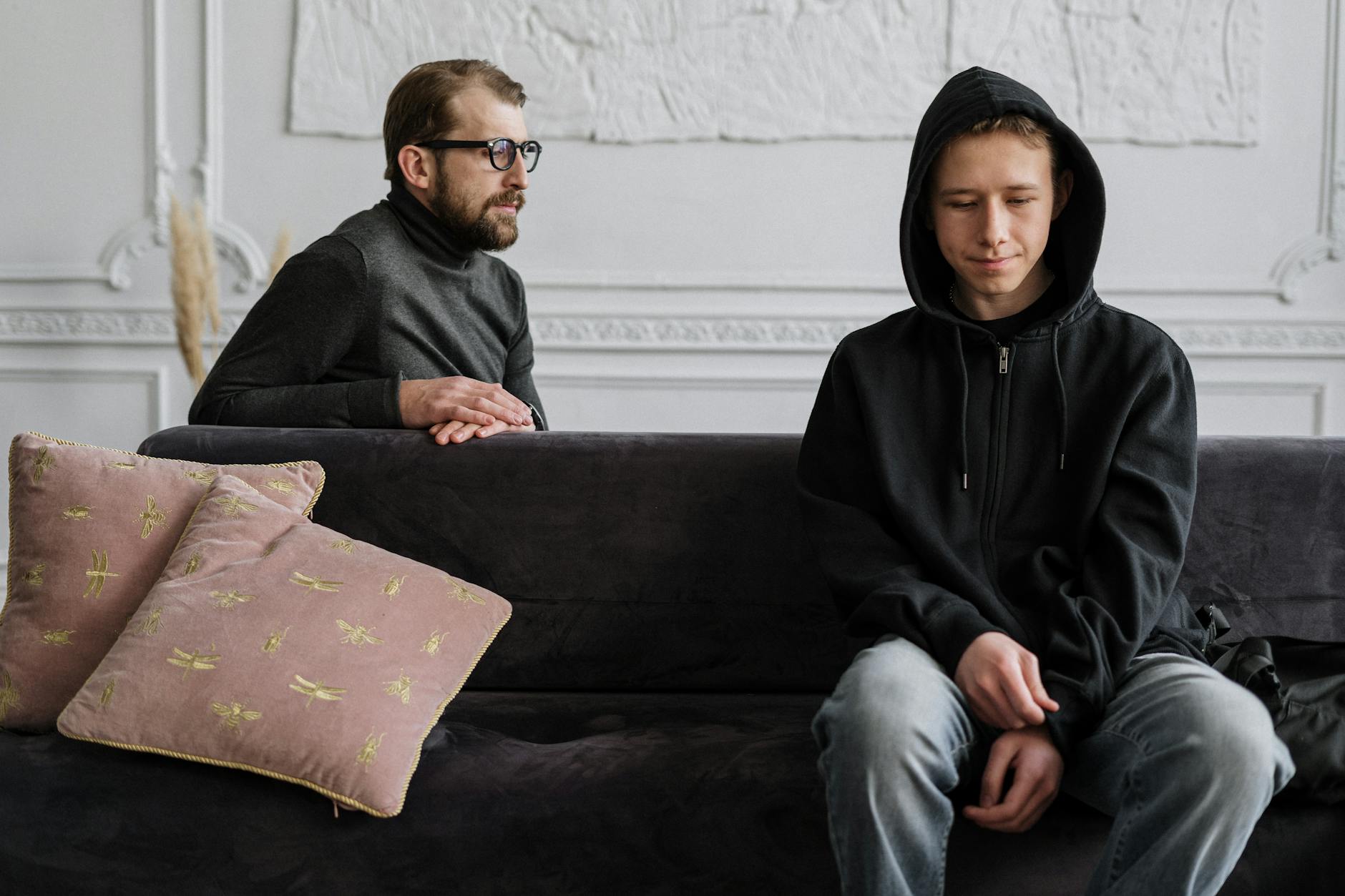 Teen in black hoodie during a therapy session in a calm indoor setting. - teen mental health