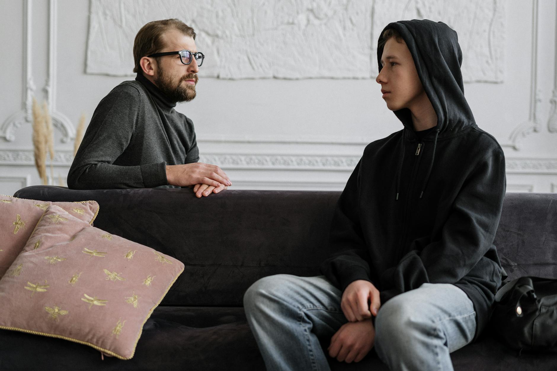 A psychologist and teenager engage in a counseling session in a cozy office setting. - teen mental health