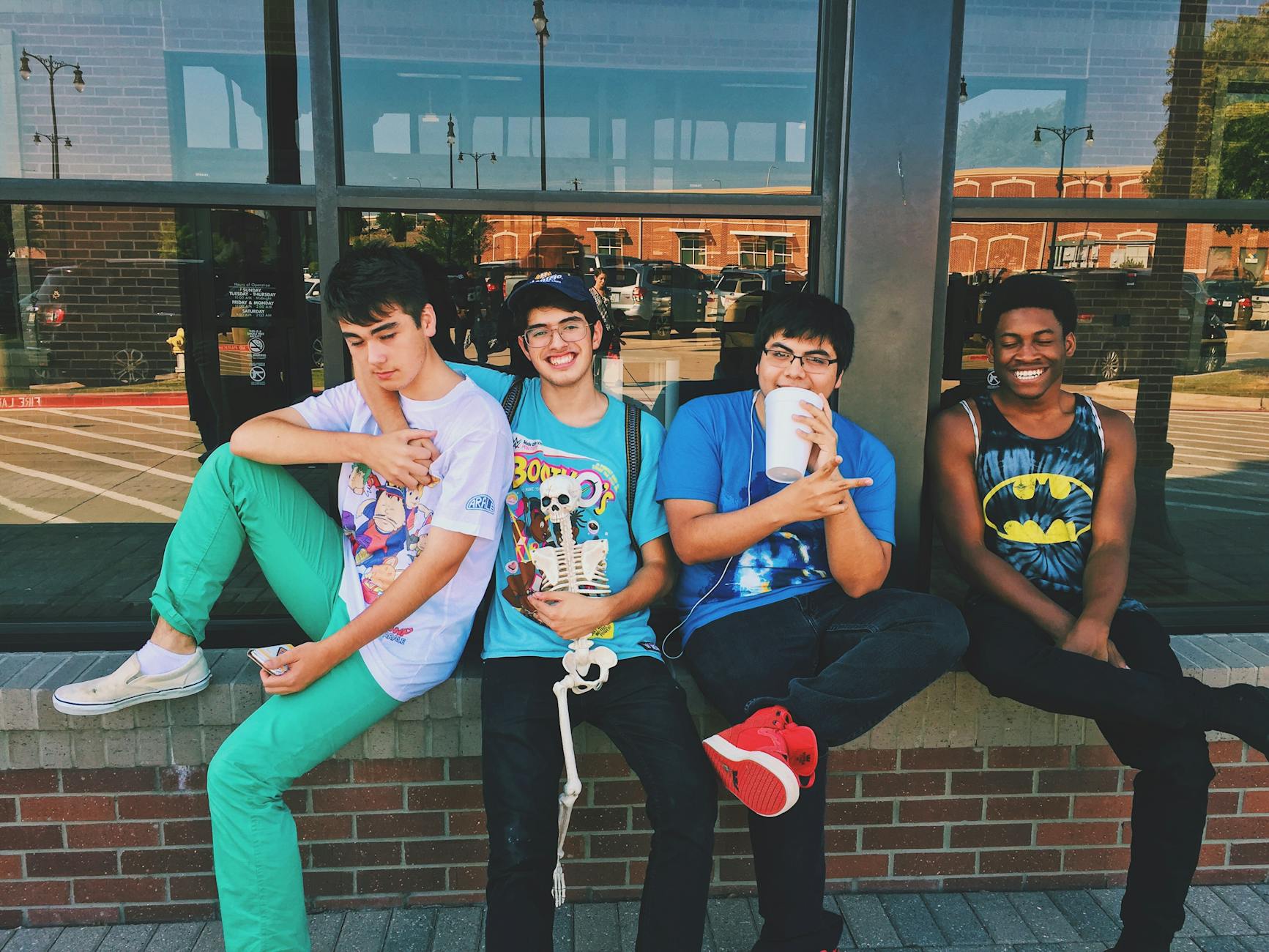 Group of teenage friends sitting outdoors, smiling and having fun together. - teen summer plans