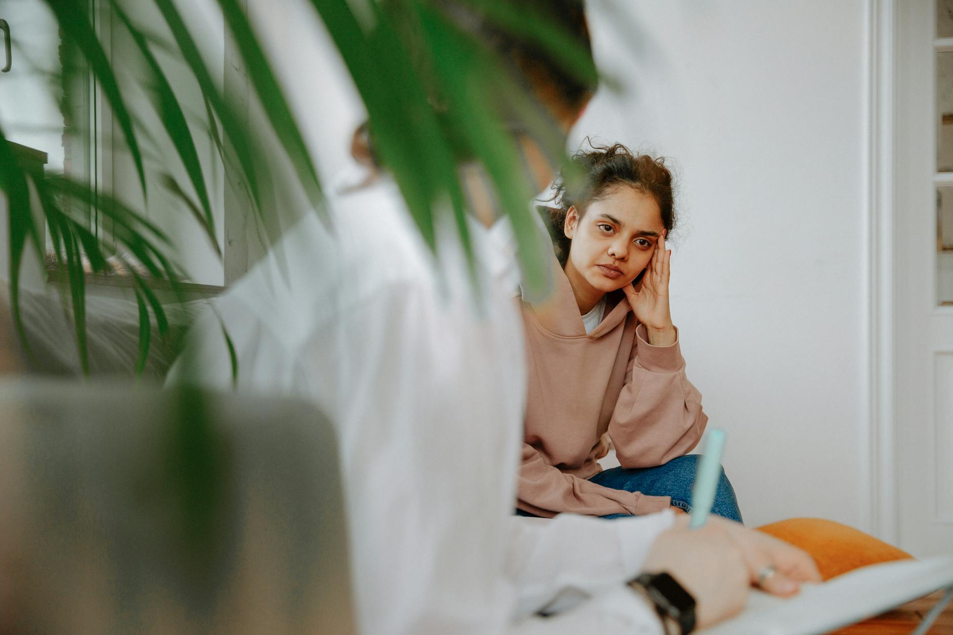A woman in a therapy session, engaging in a thoughtful discussion with her therapist. - therapist for depression