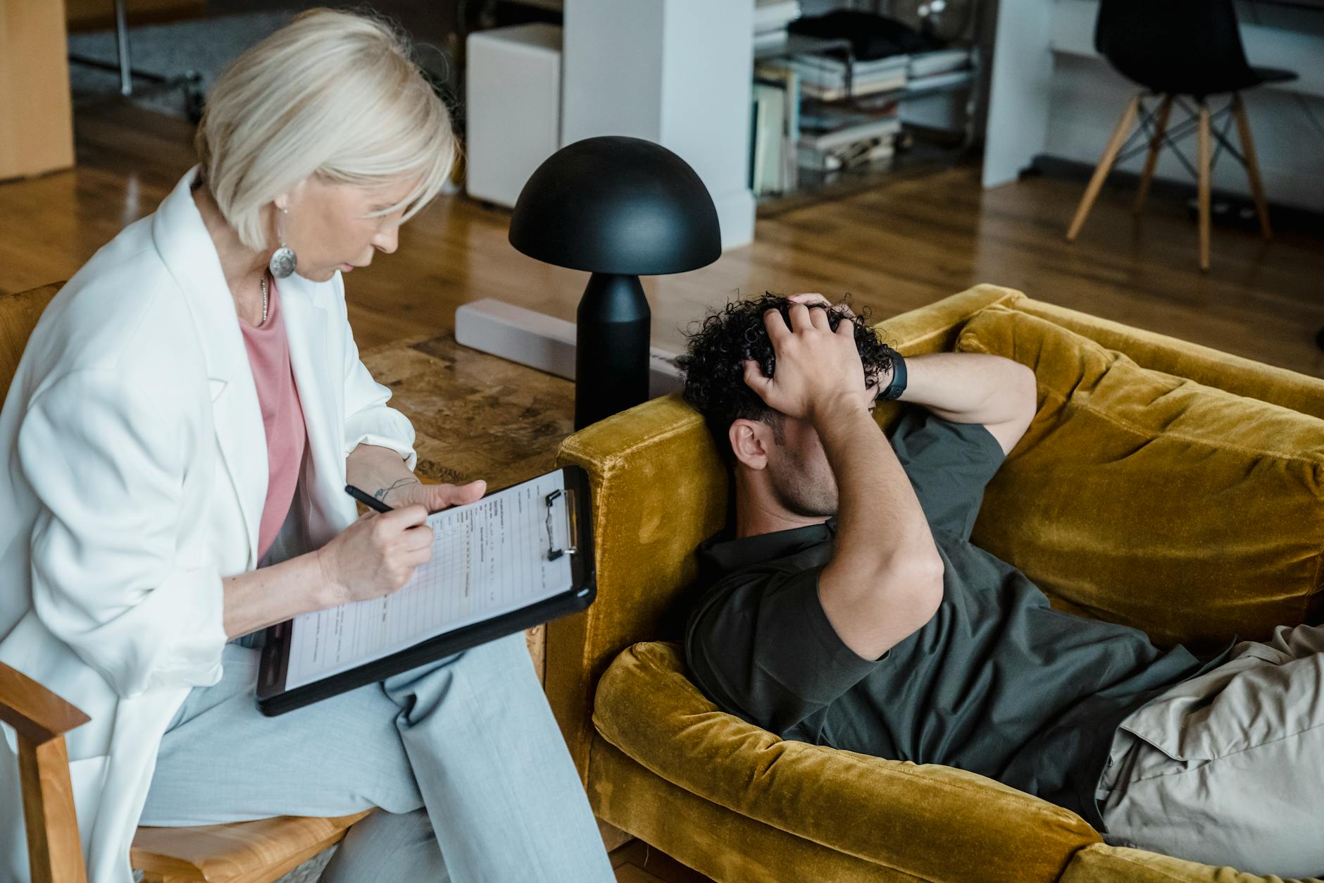 A therapist conducts a session with a client discussing mental health in a cozy office setting. - therapy for burnout