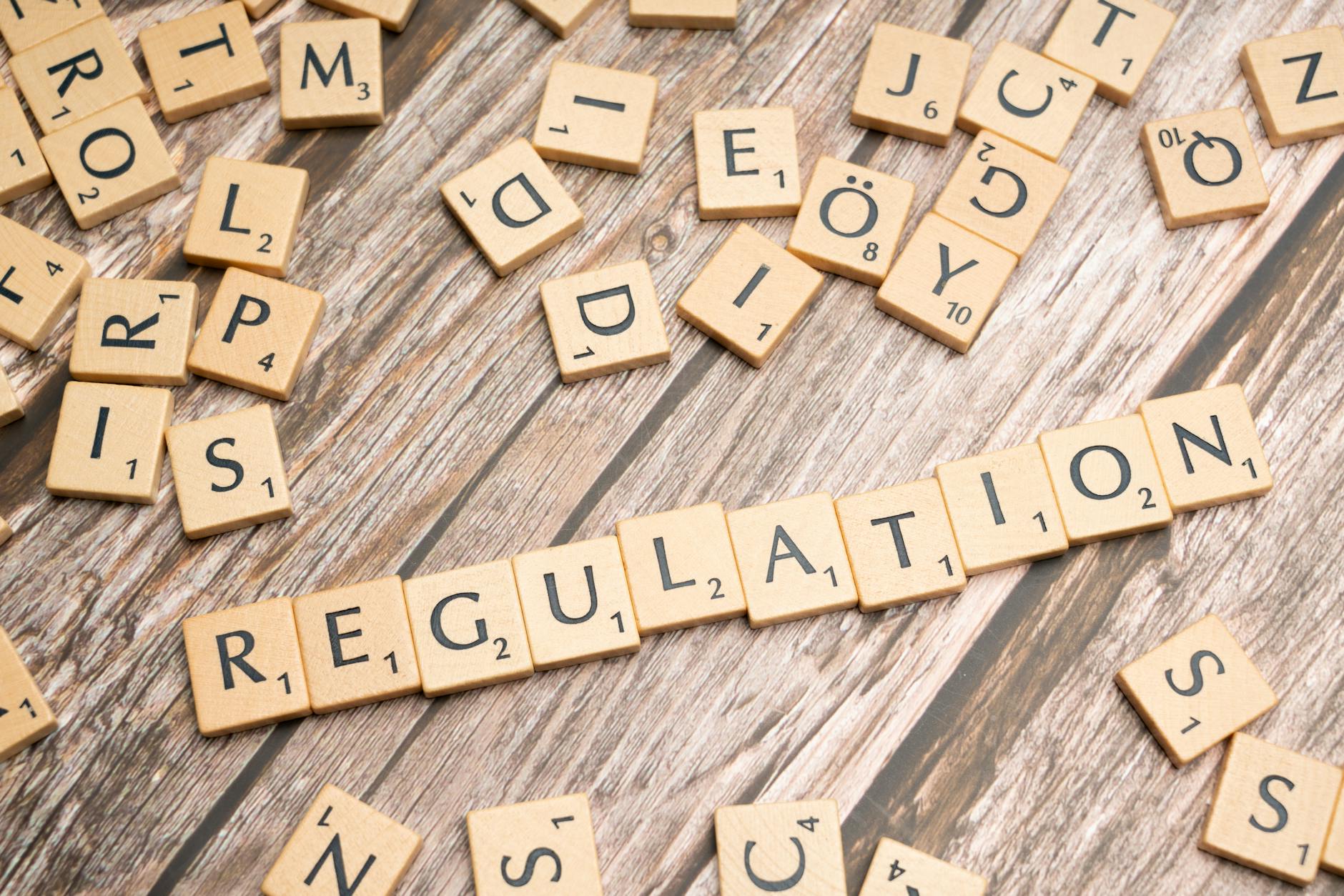 Wooden letter tiles spelling 'Regulation' on a textured wood background, conveying themes of compliance and structure. - toddler emotional regulation